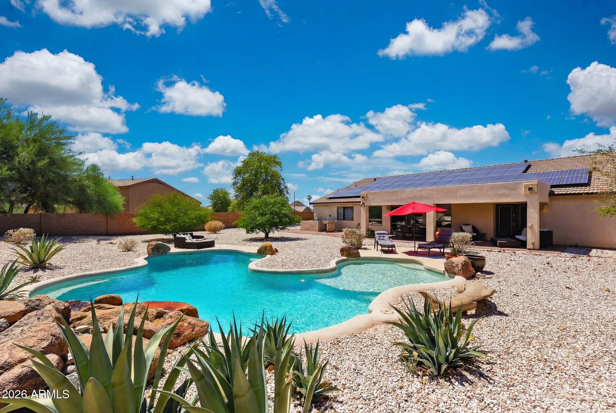 Combining modern updates, generous living spaces, and an unforgettable custom feature, this home is truly unlike anything else on the market. Situated on an oversized 15,280 sq. ft. corner lot, this highly sought-after Sterling floorplan offers 4 bedrooms, 3 bathrooms, and a spacious open-concept design filled with  distinctive character. Adding a truly one-of-a-kind touch, the home features impressive floor-to-ceiling barn doors crafted from reclaimed wood sourced from Johnny Cash's former tobacco barn a remarkable conversation piece. At the heart of the home, the beautifully appointed kitchen showcases a large granite center island, updated appliances, and views of the expansive great room, creating the perfect space for entertaining and everyday living. Updated flooring, a newer roof, and replaced HVAC systems provide comfort and peace of mind.The remodeled primary suite serves as a private retreat, featuring French doors leading to the extended patio, along with a spa-inspired bath complete with a soaking tub, upgraded walk-in shower, and designer finishes. Secondary bedrooms are generously sized, while the upgraded guest bath features granite counters. A third full bathroom adds flexibility for guests  or multi-generational living. Step outside to enjoy the expansive custom brick-lay patio, updated pool with a water feature, and oversized backyard, which offers endless possibilities for relaxation, recreation, and entertaining.
Beyond the home, discover the exceptional lifestyle that makes Estrella one of the West Valley's most sought-after master-planned communities. Surrounded by breathtaking mountain vistas, residents enjoy lakes, golf, resort-style amenities, indoor and outdoor pools, fitness centers, pickleball courts, hiking trails, dining, local shopping and an abundance of community events designed to bring neighbors together.