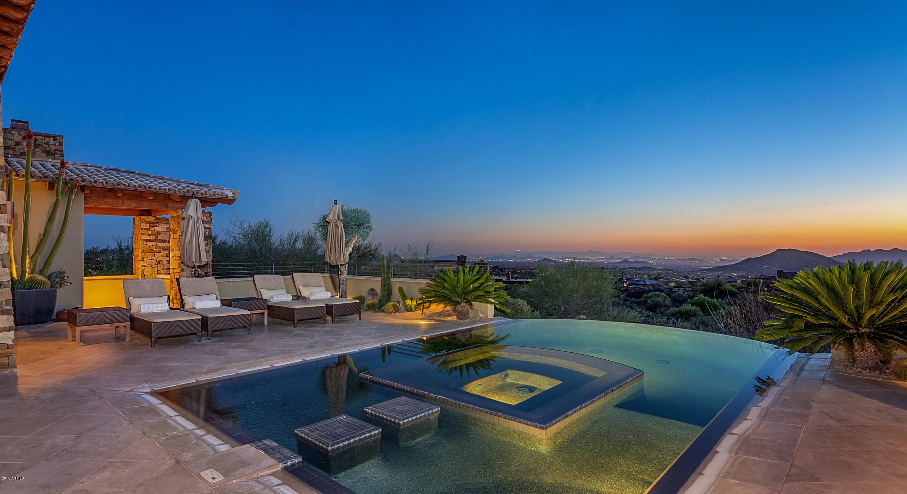 FIRST TIME EVER ON MARKET! This stunning contemporary provides both cutting edge design and inviting warmth. The great room encompasses space for entertaining and dining with a wall of pocketing doors that open up to the terrace and spectacular views of the entire valley. The gourmet kitchen with massive center island opens to a cozy family room with gas fireplace with travertine/wood surrounds. The master suite has french doors to the terrace, a warming fireplace and a luxurious bath. A guest ensuite with private patio is tucked away in the main home. A spacious attached guest quarters with two ensuite guest rooms and a lovely sitting room is accessed from the courtyard. The resort-style terrace with infinity pool with spa inset make the perfect setting to enjoy the magnificent vistas.