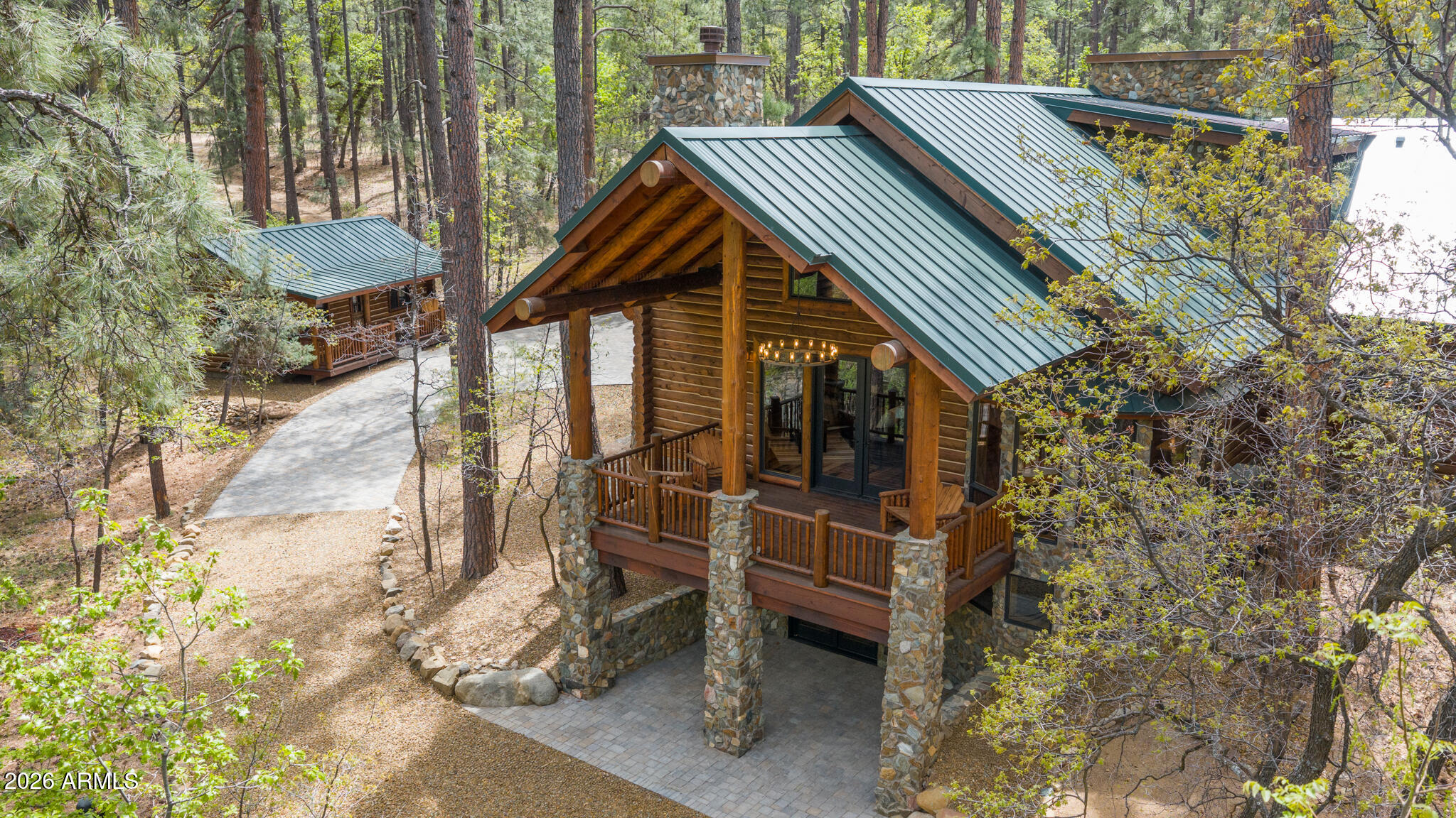 Tucked away on 2.4 acres of pristine, wooded land, this newly built custom luxury log cabin offers a rare blend of craftsmanship, privacy, and natural beauty in the heart of Prescott. Spanning 3,320 square feet, this stunning residence features 3 bedrooms, 2 full bathrooms, and 2 half baths, thoughtfully designed to capture both comfort and elevated mountain living. From the moment you step inside, you're greeted by soaring cathedral ceilings and a dramatic floor-to-ceiling stone fireplace that anchors the main living space. Reclaimed Tennessee wormwood flooring runs throughout, adding warmth and character, while custom ironwork railings provide a refined, artisan touch. The open-concept layout flows seamlessly throughout the main level, while the walkout basement unveils a spacious game and entertainment room, perfect for hosting, relaxing, or creating the ultimate gathering space with direct access to the outdoors. Large windows and expansive doors invite the surrounding landscape in, showcasing serene forest views from every level.
Step out onto the raised deck and experience true tranquility as Groom Creek winds through the back of the property, creating a private, serene setting that's hard to replicate.
The property also includes a ready-to-customize guest house, offering endless possibilities for multi-generational living, rental income, or a private studio. Car enthusiasts will appreciate the oversized 3-car garage, designed to accommodate a collection.
No expense was spared in the construction of this home, with carefully selected materials and thoughtful details throughout, including the use of logs and stone sourced directly from the property, seamlessly tying the home into its natural surroundings.
This is more than a home, it's a one-of-a-kind Prescott retreat where luxury meets authenticity.