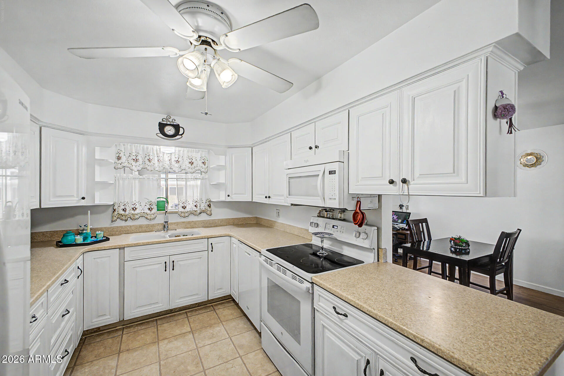 Enjoy comfortable living in this lovely home featuring an open floor plan with attractive wood-look flooring, dual-pane windows, and ceiling fans throughout. The well-appointed kitchen is designed for both functionality and style, offering soft-close cabinetry, solid-surface countertops, and built-in appliances. The spacious primary suite provides a relaxing retreat with cozy carpeting, two closets, a built-in dresser, and a private bath. An Arizona room adds valuable extra living space, perfect for hobbies, a home office, craft room, or simply a place to relax and unwind. Step outside to the south-facing backyard, with a covered patio, convenient storage areas, and easy-care landscaping designed for low-maintenance living. Ideally located near shopping, dining, hospital, & freeways.