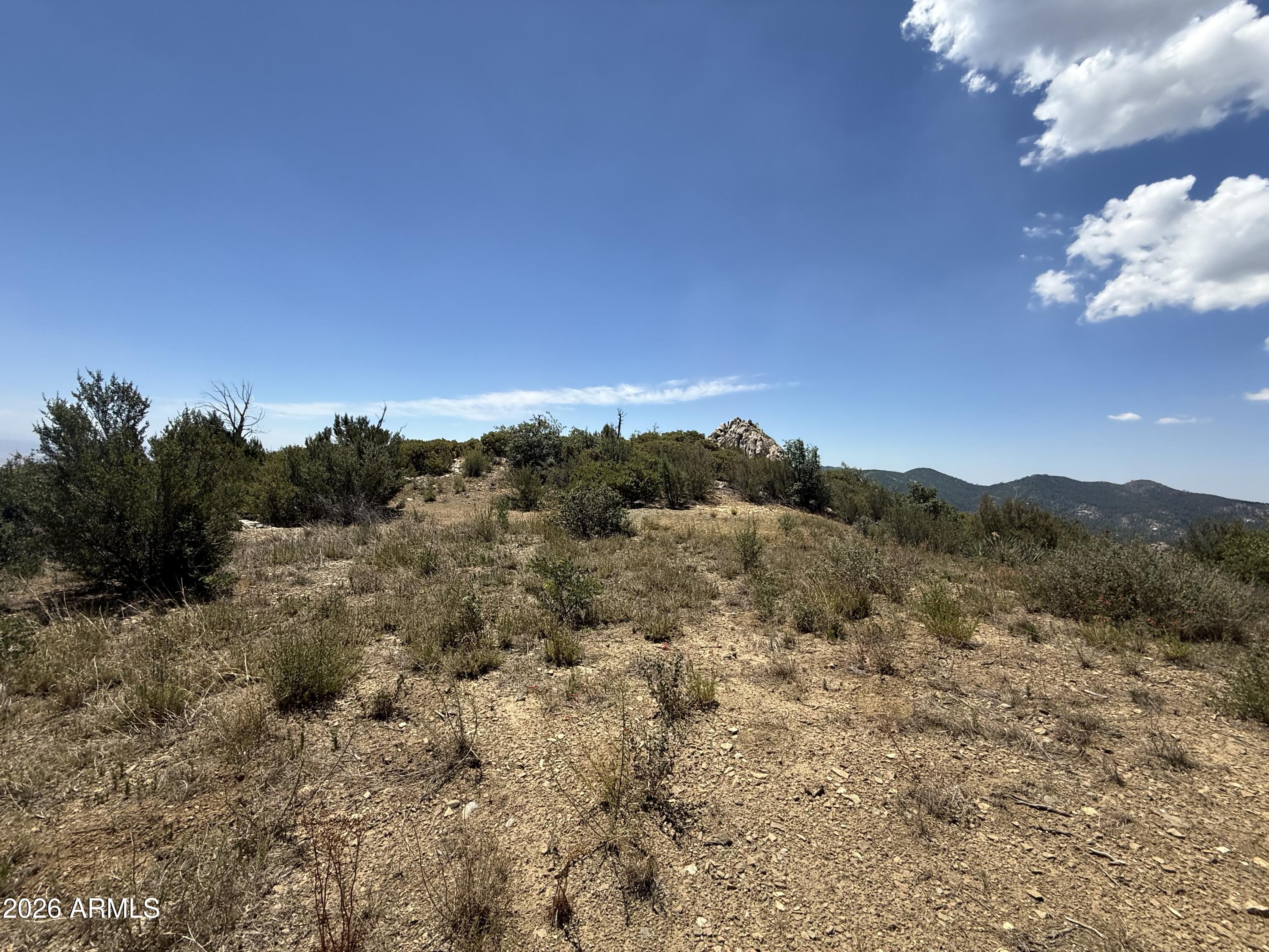 Build your own off-grid private mountain retreat! Situated just north of the historic town of Crown King at an elevation of nearly 7,000 feet, this exceptional off-grid parcel offers unparalleled 360-degree views across the expansive desert floor below. It features an ideal, ready-to-envision building site perfect for your dream getaway cabin. True mountain living awaits with four distinct seasons, and peace of mind is guaranteed as two sides of the property directly border the Prescott National Forest. This is a rare opportunity to own one of the most scenic lots in all of Arizona. This property is located behind locked gates. High-clearance 4x4 vehicles are required.