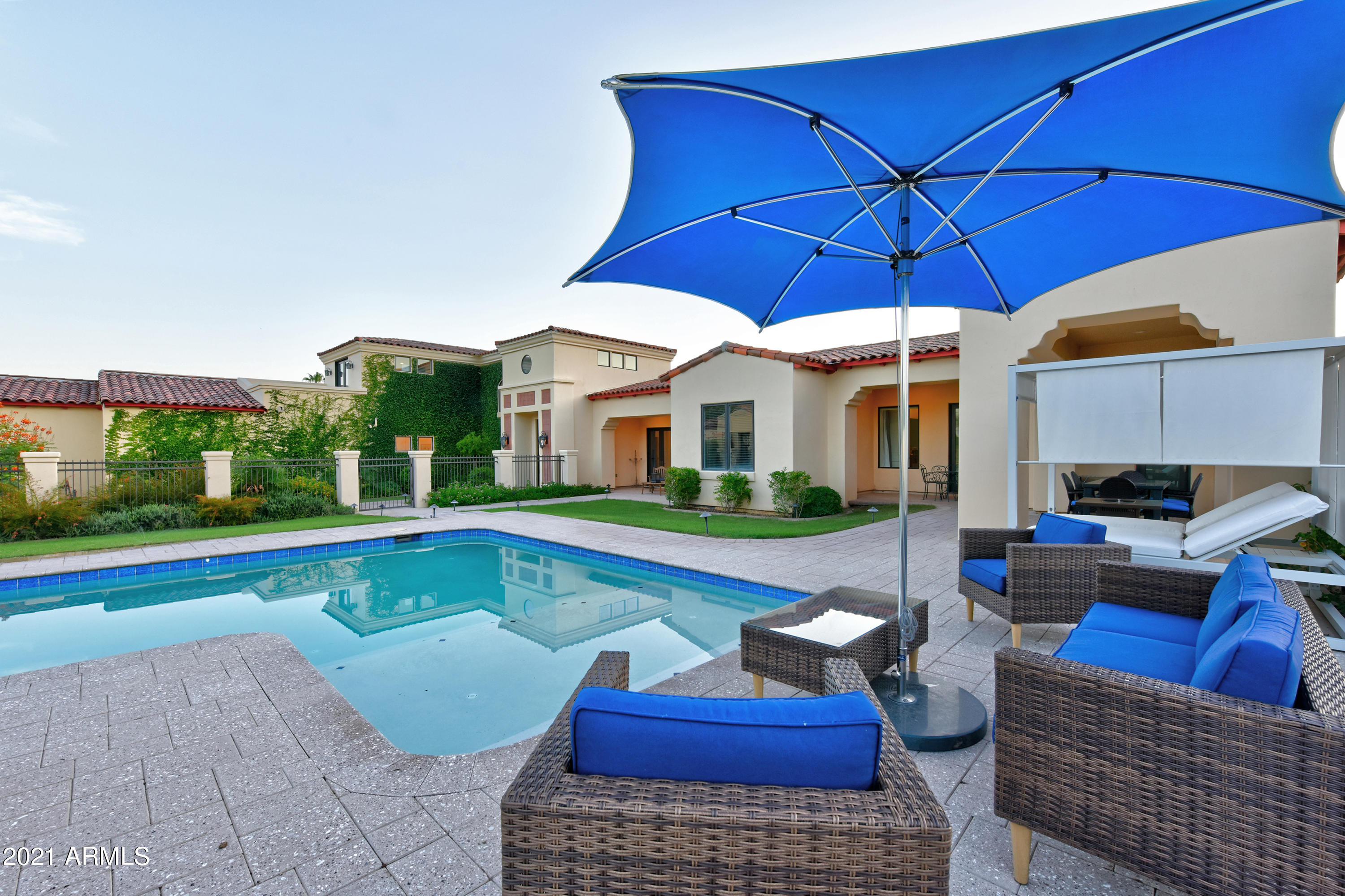 A must see Modern Santa Barbara inspired Estate recently reimagined and refreshed. You will feel welcomed the moment you walk thru the Gates.  This 5,300+ sq ft home is perfect for family living and entertaining.  There are 4 bedrooms, 6 bathrooms, plus a loft and office/den.  Master Suite and additional Guest Suite on 1st floor with additional 2 Guest Suites and gameroom on 2nd floor.  Beautiful chef's kitchen overlooks huge great room.  Master Suite has sitting area, spa like bathroom and private patio....you will never want to leave.  Large grass backyard has fig, key lime, clementine, grapefruit, and kumquat trees.  Pool area will make you fill like you at one of the classic Paradise Valley resorts nearby.  You can lounge by the pool and have your own private views of Camelback Mountai