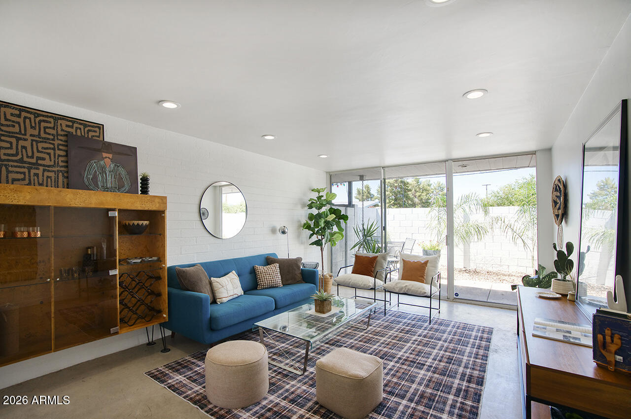 Iconic mid-century modern gem designed by legendary Phoenix architect Al Beadle. This well-maintained two-bedroom, two-bathroom condo spans 950 square feet and features his signature clean lines, geometric design, and thoughtful use of space, with block construction and walls of glass. Natural light floods the open floor plan through custom windows, highlighting the distinctive concrete floors. Step outside to your private patio, or gather with neighbors in the courtyard and take a dip in the community pool. Located in the heart of the Melrose District, within walking distance of shops, restaurants, and nightlife. Perfectly positioned near Midtown Phoenix, the freeway, and light rail.