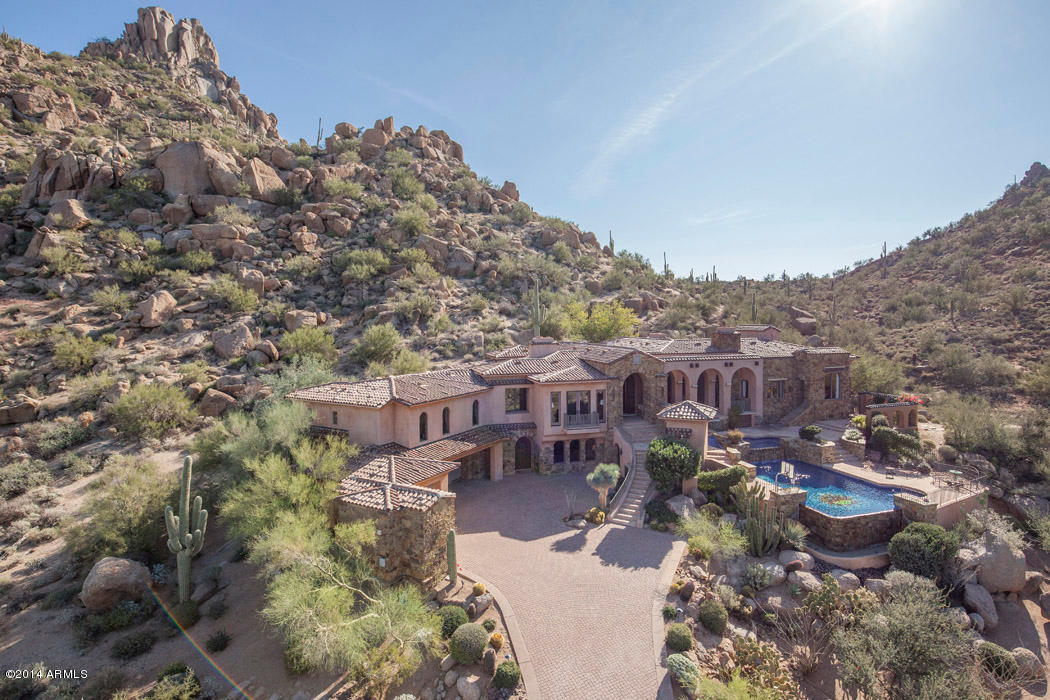 Located immediately under Pinnacle Peak and gently nestled into the hillside on the highest lot in Estancia, this property exudes the very best of desert living. Priced $1,300,000 less than previous listing, this extraordinary 4 bedroom ensuite Byrd Construction home presents an outstanding opportunity.  The finest finishes throughout are only outdone by the exceptional views. A three way split floor plan with four en-suite bedrooms is the perfect set-up, offering ultimate privacy for family and friends. Spectacular city light, mountain and golf course views complete this private get-away.