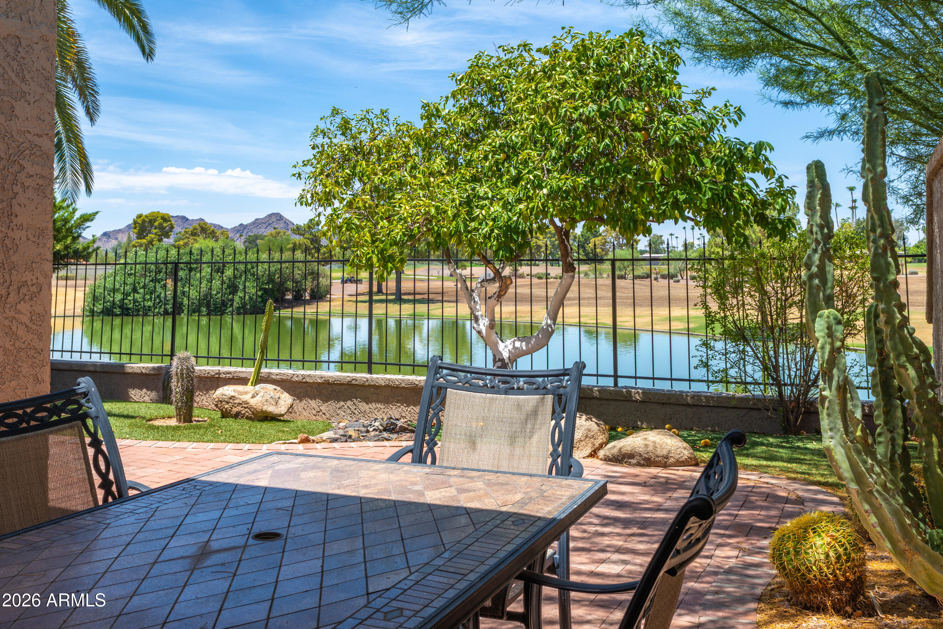 Waterfront luxury meets resort-style living in McCormick Ranch. This exceptional single-level patio home boasts direct gated access to the greenbelt and stunning, unobstructed views of the lake, Camelback, and Mummy Mountains. Relax on your private covered back patio, head a few homes down to one of the  2 community pools. Inside, a sunlit foyer with a skylight welcomes you into an expansive layout featuring a formal dining space and a gourmet eat-in kitchen with granite counters, stainless appliances, and a built-in wet bar with a wine cooler. The fireplace-warmed family room features beautiful wood-look tile and surround-sound speakers, while the split primary suite offers a private sanctuary with a large walk-in closet.