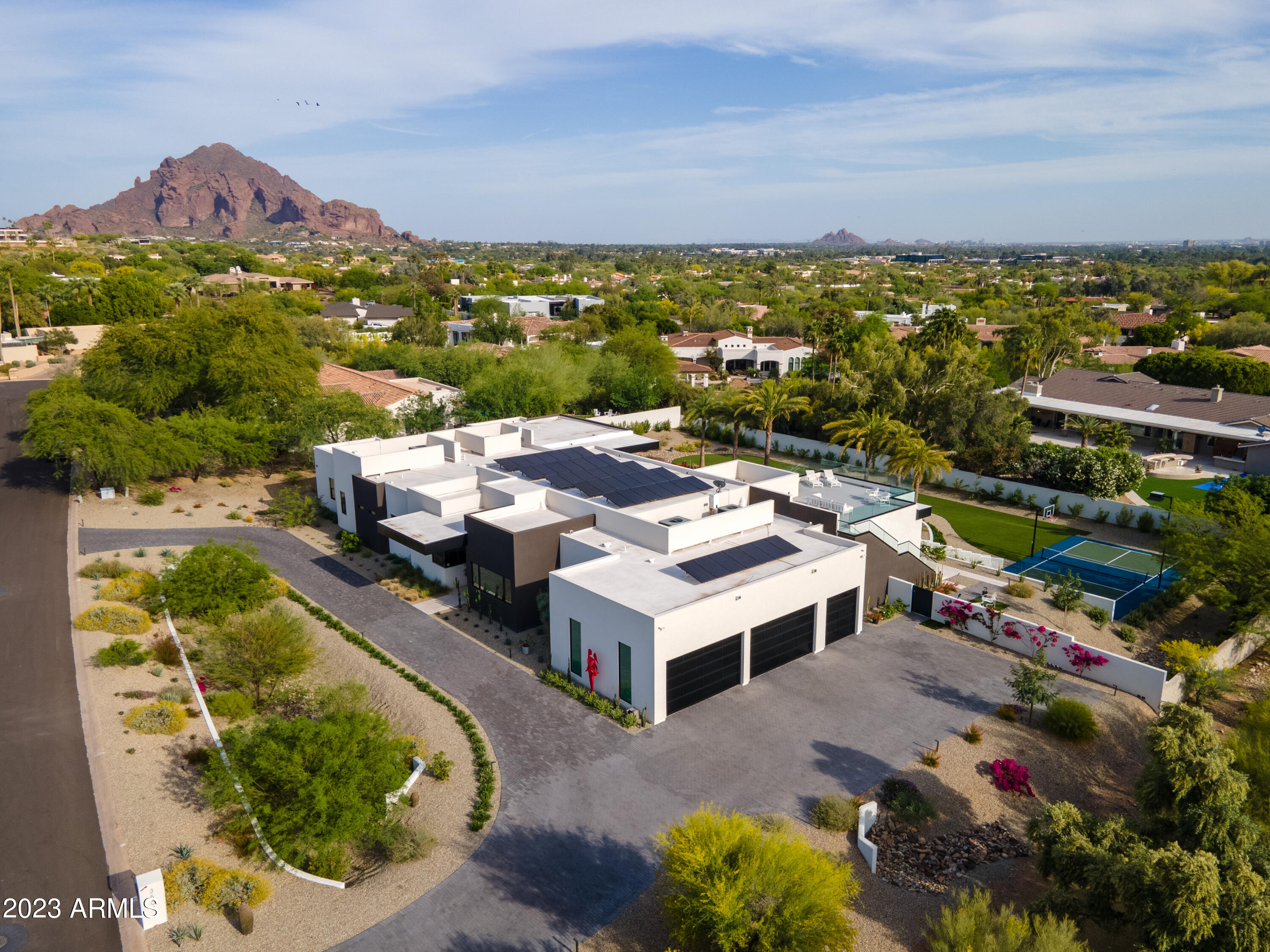 Magnificent modern contemporary home w/ 6 bedrooms plus, 6.5 baths completed with finest of design. The entrance boasts 16' ceilings w/ unobstructed views of the meticulously landscaped backyard. Large open floorplan w/ Greatroom & fireplace, complemented w/ a glass wine wall display, dining area w/ stunning mountain views. High end chef's kitchen, 2 oversized islands & butlers pantry makes for enjoyable indoor entertaining. Gorgeous backyard has a covered patio with misters/heaters/2 way fireplace, dining & BBQ area. A complete oasis w/ heated pool & spa. Outdoor lighted sports/pickleball court & colorful rose garden. The roof top patio lights up with majestic mountain & city light views.
Grand primary suite w/ sitting area, fireplace,  and luxury bath. Full attached casita w/ kitchen.