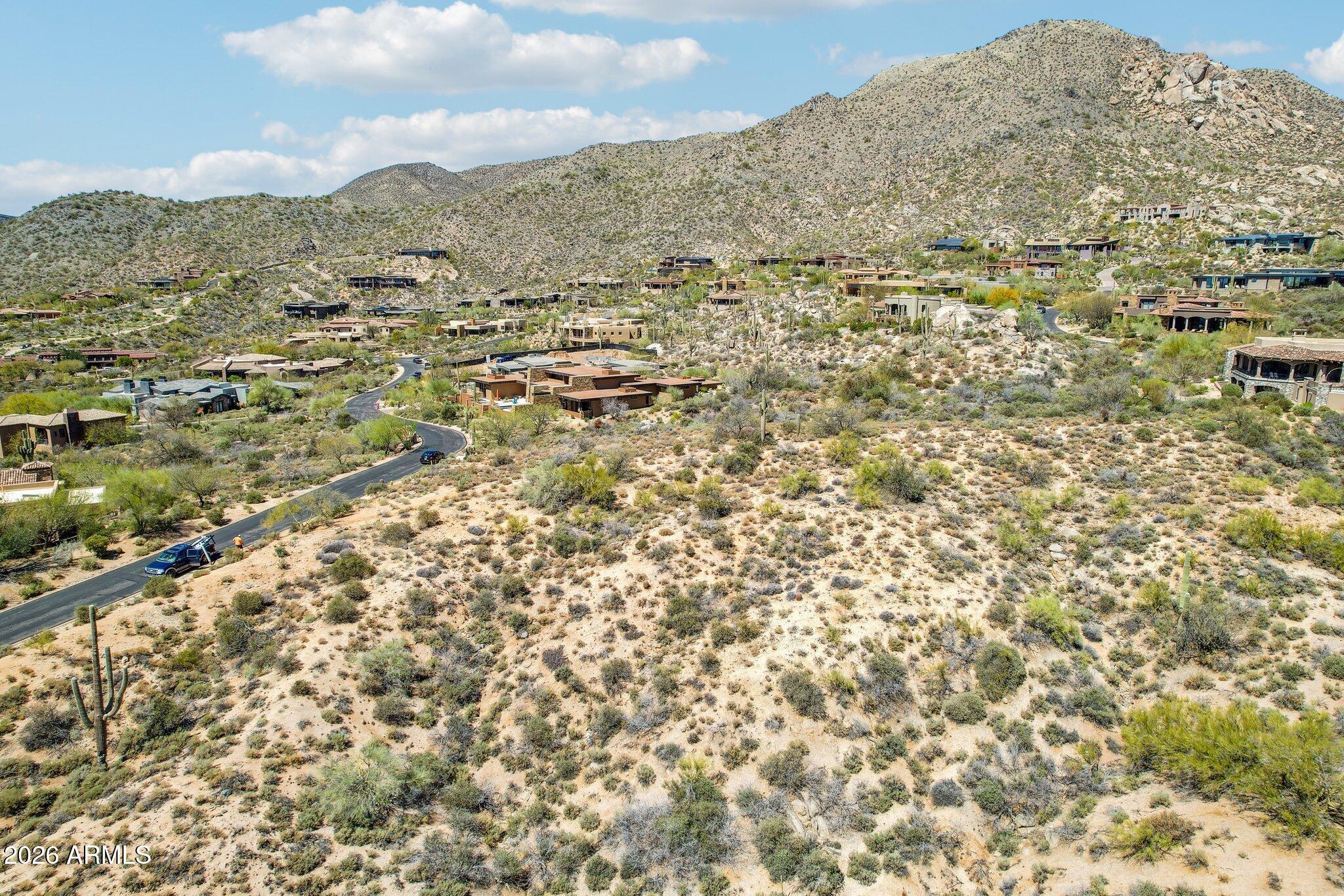 Welcome to Desert Mountain, a premier golf and outdoor recreation-based community in north Scottsdale, AZ. This lot, one of very few left in all of DM and high (+- 3,350') in one of its highest villages (indeed, in all Maricopa County), offers: southern exposure; panoramic city light, McDowell Mountain, and winter sunset views; no extraordinary construction costs; and no noise from major internal roads, Cave Creek Road, or golfers or golf course maintenance equipment.  Effectively over 107,000 square feet in size due to an adjacent HOA-owned parcel.  Advantageous building envelope and  lot access.  No immediate access to a Desert Mountain Club Full Golf Membership, available via a wait-list, with full access in the meantime to all other activities. Read ''More'' for further insights. Lost Star 36 presents a rare opportunity for a sophisticated, forward-thinking investor to secure a premium homesite in Desert Mountain, perhaps the premier community of its type in the United States.

Ideal Buyer Profile:

A discerning individual who:

-   May not be interested in golf but sees long-term value in HOA restriction protected, gated, recreational and lifestyle-oriented property.

-   Might represent a family office focused on generational wealth and memory-rich investments.

-   Understands there are many more non-golfers in the world than golfers, and that this market segment knows and appreciates that private, gated golf communities typically have real estate more valuable than non-golf course community real estate.

-   Understands global real estate trends, especially what happens when supply completely stops, and demand keeps growing, as is the case for this caliber of lot in Desert Mountain.

-   Desires to preserve and grow wealth through assets valued for lifestyle return as much as financial performance.

-   Is focused on high-quality U.S. real estate, particularly in scenic Arizona, and in one of its most affluent developments.

-   Appreciates an opportunity to build a home in an area not known for fires, hurricanes, tornadoes, earthquakes, or other natural disasters.

Why Desert Mountain?

Buyers will recognize Desert Mountain as superior among gated communities due to:

-   High elevation, clean air, and breathtaking views.
-   Robust community features: social, recreational, and year-round engagement.
-   Access to elite healthcare and private air travel.
-   Limited supply: no additional land to develop, meaning rising long-term value.
-   Optional access to a private club ranked in the top ten in the country.

The most valuable homesites in Desert Mountain typically include: 

-   Privacy (either through size or topography).
-   No risk of noise from road traffic, or people or equipment on golf courses
-   Expansive views, and no risk of losing them due to future construction.
-   South-facing exposure, for winter sun and panoramic views (city lights, mountain ranges, sunsets).
-   Buildable land with gentle slope and no construction obstacles.
-   One-level living potential, large building envelope.
-   Central, elevated location, yet close to clubhouses and gates.

    Lost Star 36 excels on all these fronts.

Site Details:

-   Size: 31,260 sq. ft., north of and adjacent to a 76,110 sq. ft. undevelopable HOA parcel.
-   Combined Privacy Buffer: 107,370 sq. ft. (2.46 acres).
-   Elevation: ~3,350' ASL ideal for year-round enjoyment with cooler summers and mild winters.
-   Building Envelope: 18,272 sq. ft., suitable for a 6,000+ sq. ft. single-level home.
-   Driveway Access: Ideal NW entry point allows for functional design - visitor parking to the north, garage to NE, kitchen and family rooms to the sunny E and SE.
-   Protected Views: 100% protected southern views; southeast views to the McDowell Mountains are also protected: these views are over a currently undeveloped lot, but that lot is owned by a neighbor for downhill view protection and not likely to be sold separately.  If it were sold separately, the views would remain unobstructed in any event due to parapet height restrictions.
-   Noise Buffer: ~395 yards from Desert Mountain Parkway; well-removed from potential road noise.

Community Benefits:

Desert Mountain Club:

-   Membership-optional private club renowned for golf and outdoor recreation.
-   7 clubhouses, 9 dining venues, 6 Jack Nicklaus Signature courses, 4 practice ranges, and an eighteen-hole par-3 course, rated for handicap purposes.
-   The Sonoran Clubhouse supports health, wellness, and family-friendly social life.
-   25+ miles of private trails, with elevations up to 4,890' for hiking, biking, and horseback riding.
-   Dynamic social opportunities, or privacy if preferred - balance your lifestyle.

Nearby Amenities:

-   10 minutes to Carefree and Cave Creek shops and restaurants.
-   16-minute radius includes 70+ dining spots.
-   Less than 45 minutes to Sky Harbor or Scottsdale private airports.
-   World-class shopping, sports, and culture in Phoenix/Scottsdale metro.
-   2.5 hours to Flagstaff skiing; easy access to San Diego and Las Vegas; Grand Canyon and Utah's "Mighty Five" national parks also within easy driving distance.

Weather & Environment:

-   Dry, mild Mediterranean climate.
-   Fewer than 12 days annually above 100°F; 15-20° nighttime cooling even in summer.
-   Very low humidity and low natural disaster risk.
-   Clear skies, brilliant stars, and clean air.

Medical Care Access:

-   World-class institutions like Mayo Clinic and Barrows Neurological Institute are nearby.

Investment Outlook:

-   Over 2,000 homes built; 60 more under construction, fewer than 200 lots remain; of these typically only 20 to 30 are listed for sale; most of these lack locational or view advantages.
-   Most high-quality remaining lots are owned for privacy/view protection - not for sale.
-   Future buyers may have to buy and demolish existing homes to obtain top-tier locations and views similar to those offered by Lost Star 36.

Club Membership Notes:

Lost Star 36 is offered without immediate access to any membership in the Desert Mountain Club.  If one is desired, the Buyer will need to apply and wait for availability (likely a shorter period than what would be required to design and build). However, the Club currently offers "Lifestyle" (non-golf, but everything else) memberships (upgradable to Full Golf upon availability) to homesite buyers evidencing intent to build, subject to approval and applicable fees.  

Summary:

-   Premier position in one of Desert Mountain's most desirable villages.
-   Southerly exposure with expansive, permanent views.
-   Exceptional privacy and minimal development risk around the lot.
-   High-elevation, central locationcooler temps, scenic beauty.
-   Build-ready site, optimized for one-level luxury living.
-   Unique driveway access enhances design flexibility and function.

As of mid-April 2025, Lost Star 36 was the only lot for sale in the four "Penthouse" villages in Desert Mountain (Apache Peak, Lost Star, Seven Arrows, or Sunset Canyon), to offer a S our SW orientation, and strong, protected views of the McDowell Mountains, the valley floor (for dazzling "city light" views after dark), and winter sunsets.  Furthermore, only one homesite remains in these elevated villages that is not owned by a neighbor to protect their view or privacy that offers views and site characteristics similar to Lost Start 36.   That lot is Apache Peak 111.  It has been owned since 1998 by a very wealthy family whose Family Office Manager has informed me that it will pass to a son after his mother passes.  So, very likely, this is the last lot left in Desert Mountain with these characteristics that one could buy.    

For the refined buyer who understands the uniqueness of this opportunity, Lost Star 36 is more than land - it's a long-term legacy asset that combines beauty, privacy, and lifestyle. If this sounds like an opportunity you'd like to explore further, we hope to hear from you!