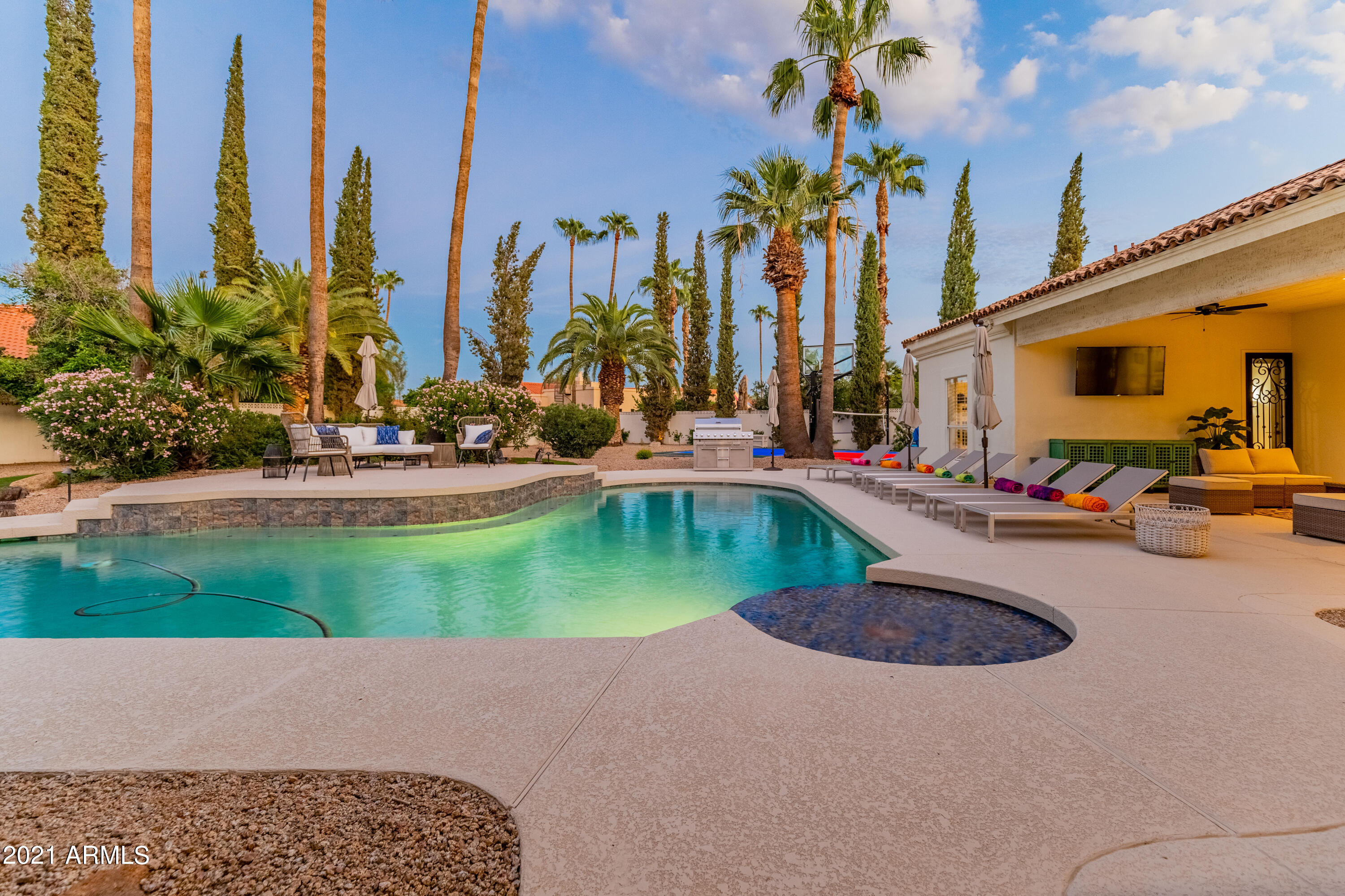 Experience luxury desert living in this stunning Cactus Corridor estate, ideally situated on a premium corner lot with mountain views and a large circular drive. This spacious home features a split open floor plan with 5 bedrooms, 4.5 bathrooms, and an additional bonus room—perfect for flexible living. Vaulted ceilings and expansive windows welcome you with abundant natural light and picturesque views of the resort-style backyard. The large designer kitchen opens seamlessly to the family room, creating an inviting space ideal for gatherings and everyday living. Step outside to your private retreat, complete with a sport court, putting green, sparkling heated pool, and hot tub—designed for relaxation and entertainment. No HOA
