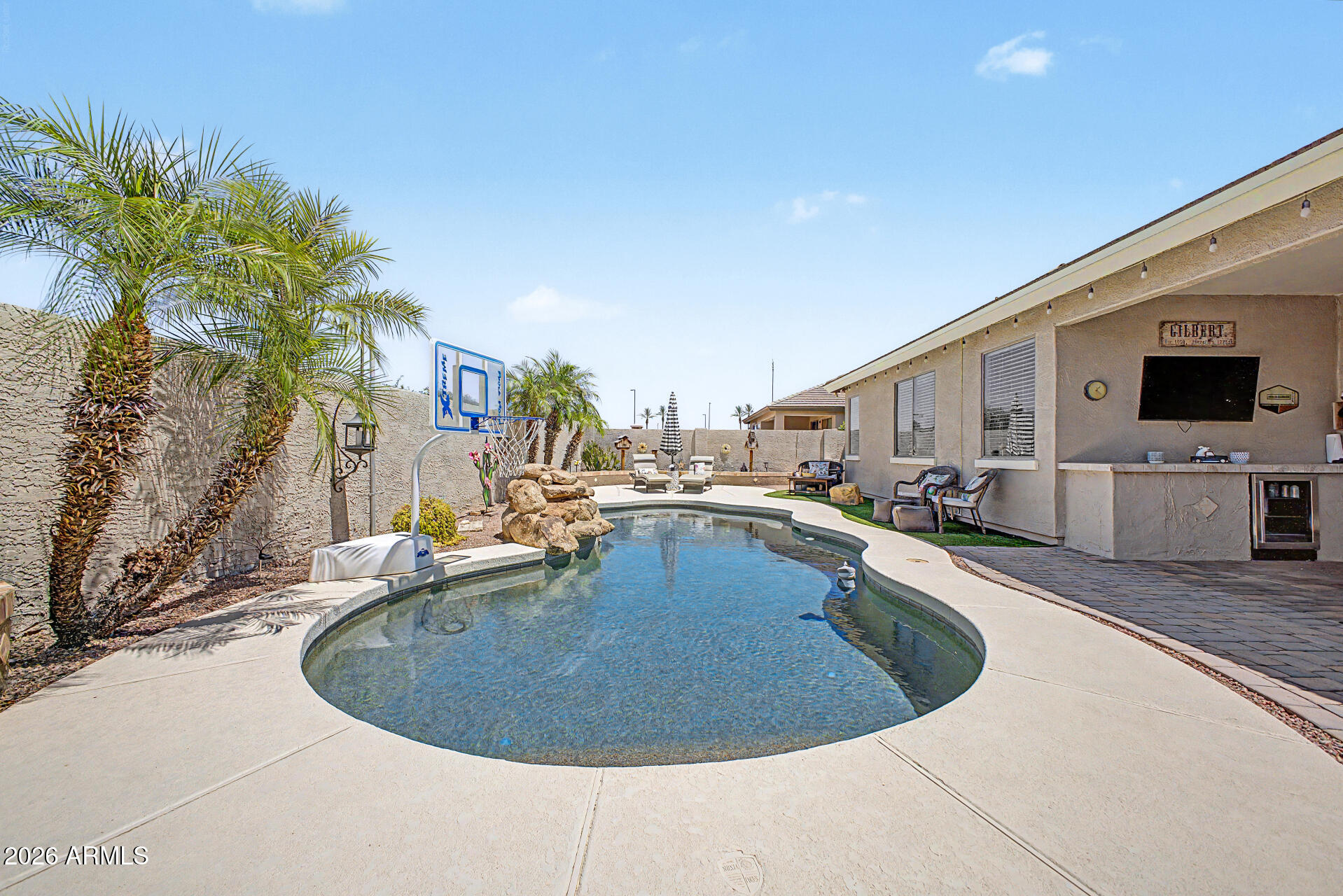 Home, sweet home! This stunning gem is located in the prestigious Seville Golf and Country Club community of Gilbert featuring an attached studio CASITA with full bathroom. Be impressed as you enter this gorgeous home, featuring a harmonious open floor plan with 3 bedrooms, office, family room, bonus work room, open formal dining, living room and designer kitchen, boasting an island with breakfast bar and a pantry. The main retreat showcases a private bathroom, with custom barn door entry, dual sinks, separate shower/tub, spacious walk-in closet and separate water closet. You'll love hosting memorable get-togethers in the private backyard oasis including a sparkling pool with waterfall, covered patio with beverage fridge, built-in BBQ, and synthetic grass lounging area. Huge side yard with massive 8ft RV gate, extending out to additional pavers expanding the drive up to the 2-car garage.