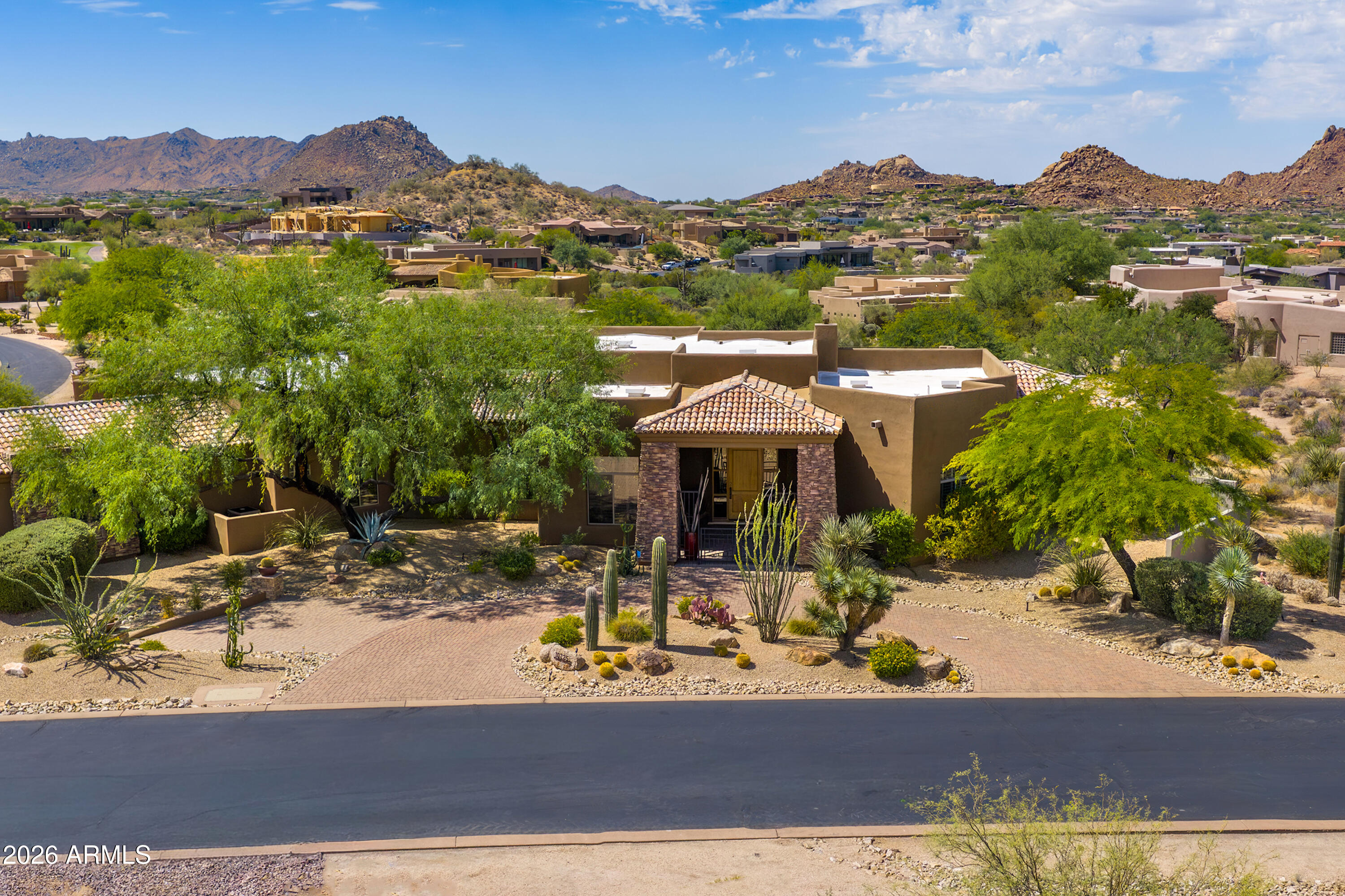 Experience the pinnacle of luxury desert living in this exquisite estate, available with furnishings (excluding artwork) at the listed price. Situated within the prestigious, golf-gated community of Talus at Troon North, this resort-style residence offers breathtaking, south-facing panoramic views of Pinnacle Peak, Troon Mountain, and Tom's Thumb.
The chef's kitchen is a culinary masterpiece, featuring updated granite countertops, a premium gas cooktop, double wall ovens, a warming drawer, dual dishwashers, a newer Wolf microwave, and a spacious walk-in pantry. It seamlessly connects to a grand great room, complete with a fully equipped wet bar, including a beverage cooler and a new ice maker, all set against a backdrop of stunning mountain vistas.
Designed for privacy, the split floor plan includes a master suite sanctuary with a stone fireplace, jetted tub, and custom safe. Additionally, there is a spacious separate casita with direct pool-bath access, two guest bedrooms, and a dedicated office/den.
The backyard is an entertainer's dream, featuring a heated negative-edge pool and spa, extensive travertine tiles, a gas fireplace, firepit, built-in grill, and a viewing deck offering awe-inspiring 360-degree views. Car enthusiasts will appreciate the expansive 4-car garage, complete with epoxy floors, custom cabinets, and a fully climate-controlled workshop.
Recent upgrades include a brand-new roof in December 2024, new HVAC units installed in 2016, $70,000 in custom landscaping, updated LED lighting, and new lighting fixtures in the breakfast room, dining room, and front entrance. Luxury Desert Living at its Finest!