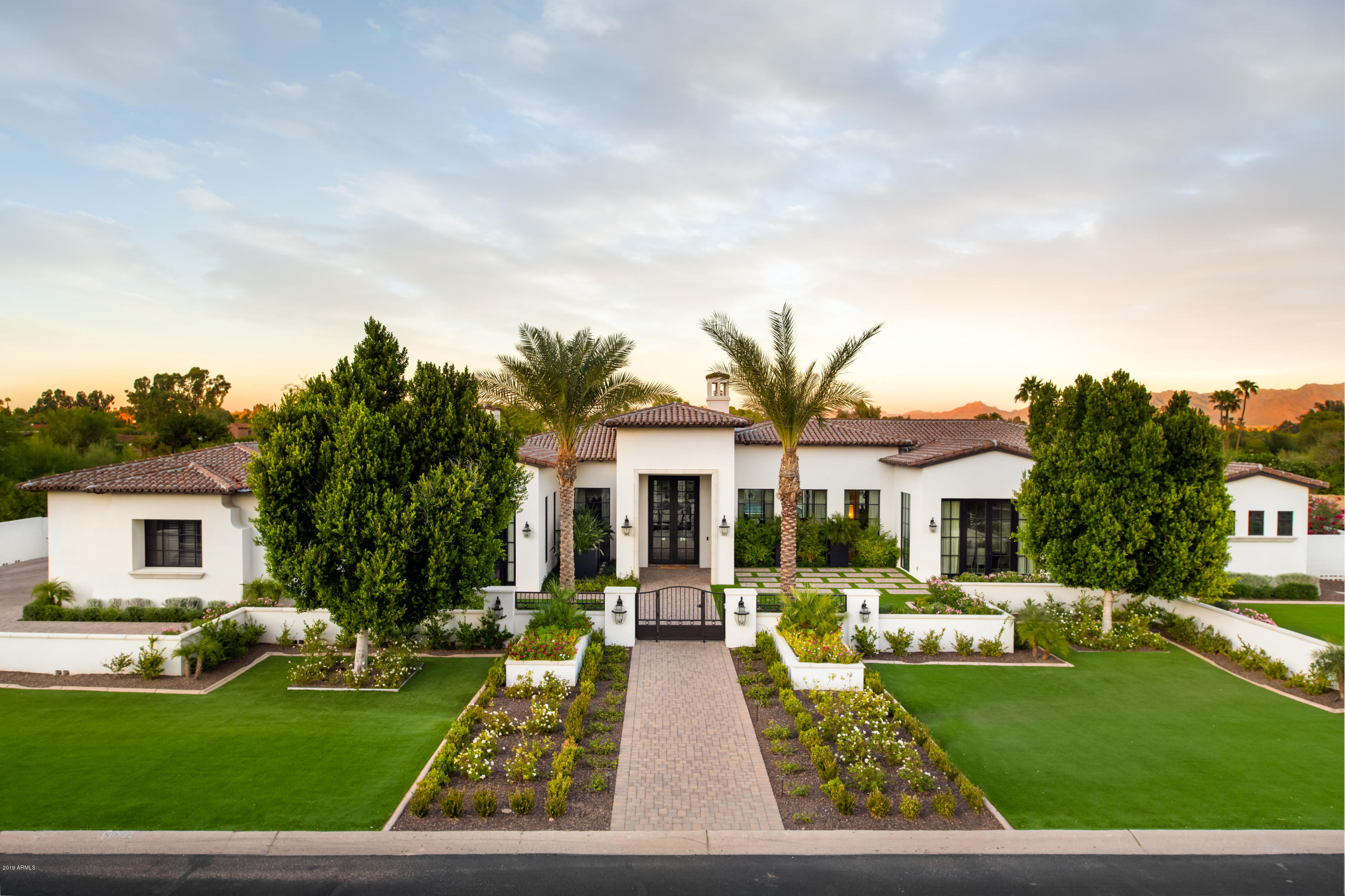 Modern Mediterranean estate completed in 2018. Every detail was carefully chosen by the owner when designing this custom home. Privately gated entrance is adorned with layers of lush landscape, and synthetic turf for easy maintenance. Enter into a spacious foyer with 14' groin vault ceilings that opens to an (appx) 44'x40' great room & kitchen. The disappearing 10' sliding doors bring the outside in! 13ft Carrara Marble island is the focal point of the kitchen, with custom hood, built-in Wolf coffee maker, butler's pantry and tons of storage. 5 spacious bedrooms all with full en-suite baths and walk-in closets. 5th bedroom is perfect for an office with its own separate entrance from the front of house. Game room has a built-in wet bar and custom lighting, and sliding doors that disappear into the walls and open to the 3,000+ sf patio. Wine room holds over 930 bottles. State-of-the-art Control 4 system makes life easier by operating all lighting, surround sound inside and out, all televisions, pool and waterfall & climate all with just the touch of a button. Elaborate heated lap pool is complete with swim up bar seating, LED waterfall, two covered ramada's with outdoor kitchen, living room and fireplace. Sprawling lawns and mountain views make a perfect setting for kids at play, or a large garden party. So much more to appreciate!