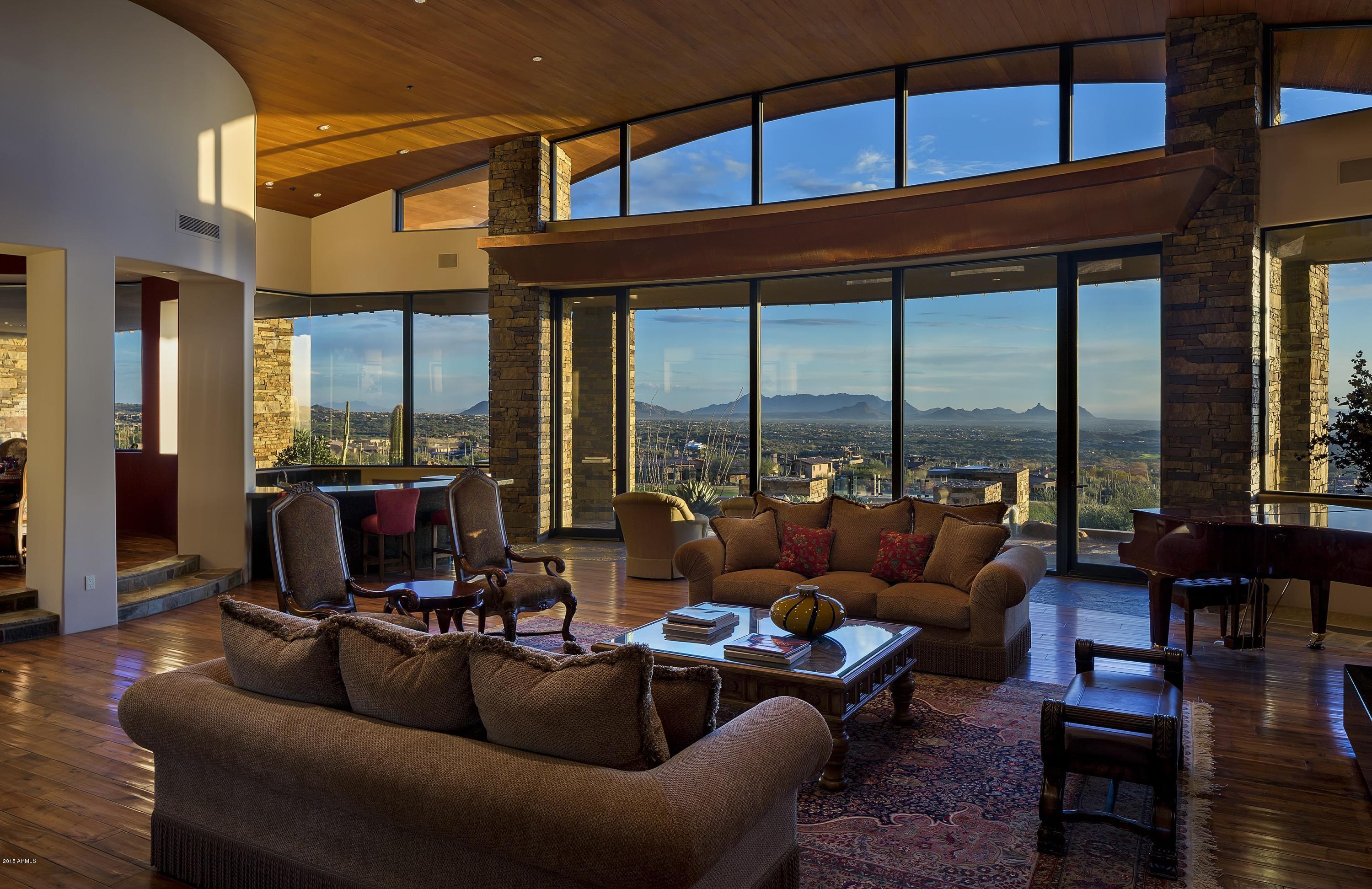 Absolutely gorgeous unobstructed views of the Chiricahua golf course, mountains, city lights and year-round sunsets are yours from this home high atop Desert Mountain. The sophisticated design by Bing Hu and the eclectic combination of materials and finishes work in concert to create one of Desert Mountain's most unique homes. State of the art home theater, 2 powder rooms, exercise/flex room, 1 full and 2 drawer dishwashers, refrigerator plus double refrigerator drawers, air-conditioned garage, wine room, and more! Finishes include walnut and cherry flooring, Venetian plaster, vaulted and domed ceilings. Gorgeous paneled office/library, Crestron system...truly a must see for your discerning clients!View “Documents Tab” for location within Community and Village.