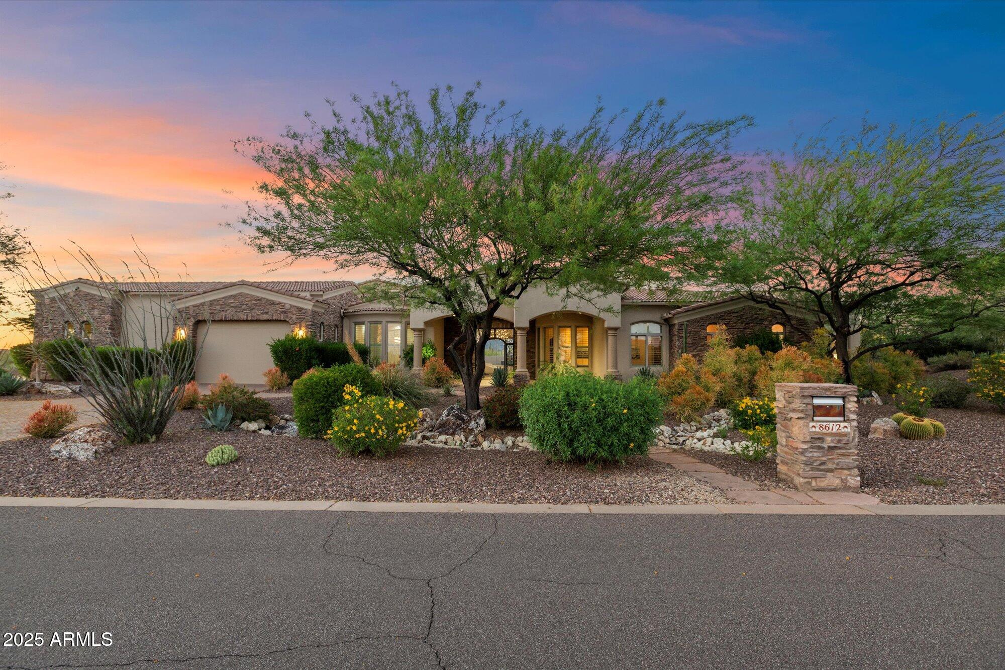 This North Scottsdale custom estate sits on a private corner lot with north-south exposure and no HOA; a rare blend of luxury & privacy. This gorgeous home features 4 en-suite bedrooms, game room, plus a second master w/separate living room & kitchen(ideal for multi-gen living or guests). Through the iron door entry the columned foyer sets the tone with elegant arches, tray ceilings, and a striking butt-glass window that frames a true work of art: the Continental Mountains. The skylight-filled great room is where all the action happens, connecting to an entertainer's kitchen outfitted with Sub-Zero, Wolf, and Asko appliances, an oversized granite island + bar height breakfast bar, alder cabinetry, a reverse osmosis system, and a walk-in pantry. It flows into a full wet bar, stone fireplace, and formal dining room with a wine chiller and butler's pantry.
The primary suite offers a private sitting area, a stone-clad fireplace wall, solid alder French doors, wood floors, art niches, and a spa-style bath featuring dual vanities, two water closets, jetted soaking tub, and a walk-through masterpiece shower with a groin-vaulted tile ceiling, body sprays, dual showerheads, and a perfectly placed window for natural light. The custom closet includes peek-a-boo windows and rich woodwork.
Additional highlights include Control4 home automation, central vac, built-in speakers, multiple fireplaces, art niches, and soaring 12'-15' ceilings. The 4-car garage features epoxy flooring, built-in storage, a separate gym space, and the capacity to accommodate a lift.
Outdoors, enjoy your own modern resort with a heated pool and spa, a cascading water feature with fire, a sun deck, a covered ramada with fire pit and TV, and an elevated lounge patio for sunset views. A pavered circular driveway and lush professional landscaping are the cherry on top. Furnishings are available on separate bill of sale AND home is available on .8 acres for $2.85 see MLS6864740