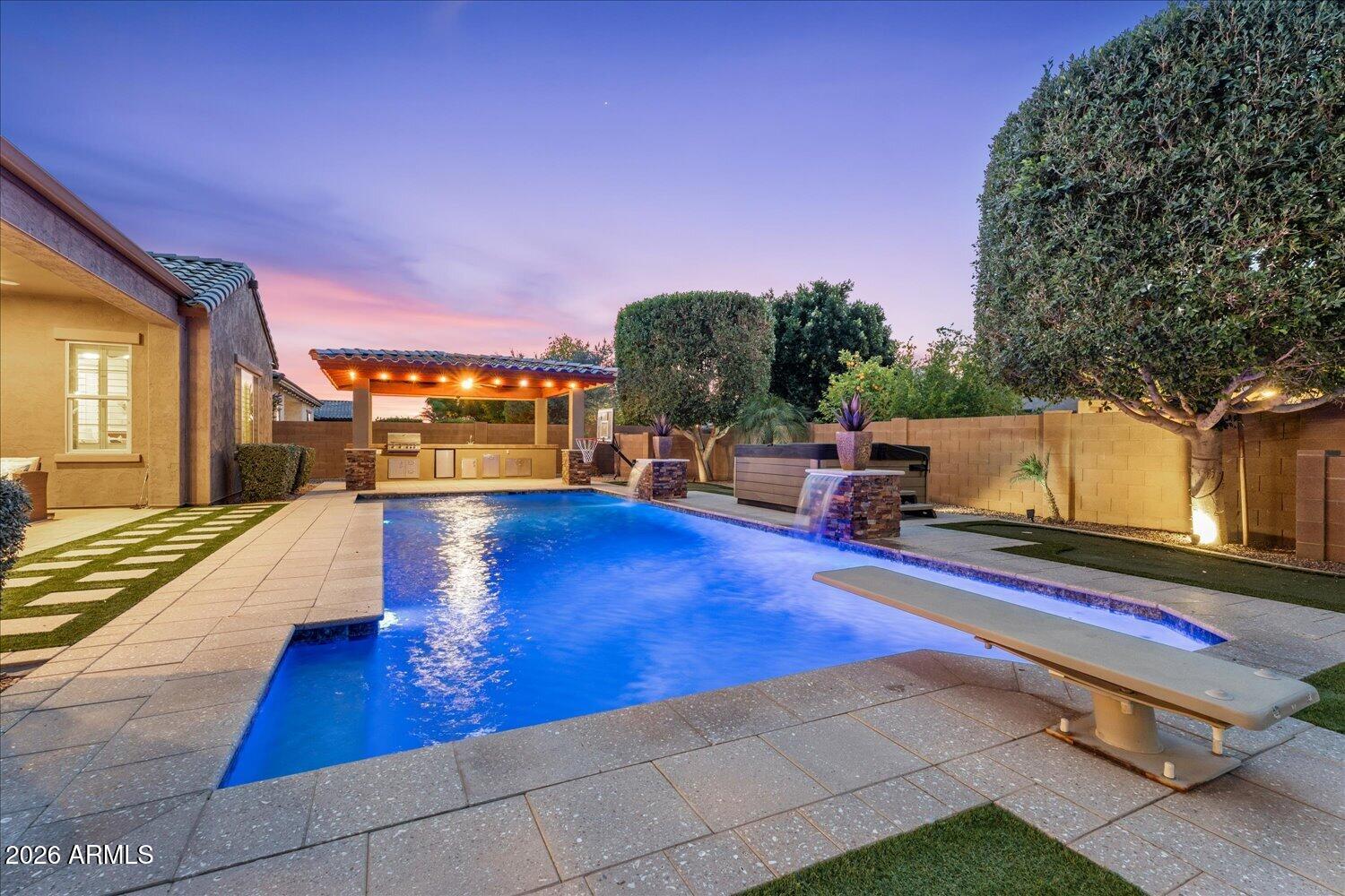 Stunning single-level home with a backyard oasis,nestled in a beautiful gated community, filled with amenities, large end lot, on a quiet street! 
Boasting PAID-OFF SOLAR, nearly 3,905 sq ft of thoughtfully designed living space, this 5 bedroom, 4.5-bath masterpiece features a beautiful chef's kitchen with a large island & gigantic walk-in pantry, spacious primary suite with a luxurious ensuite, and extended master closet, plus 2 additional bedrooms with ensuite bathrooms. 
Step outside, to your  sparkling pool with swim jet, spa, 3 putting greens, sport court & outdoor kitchen- perfect for AZ entertaining. Space, style, and security all in one. HOA Includes: Splash pad, fishing lake, playgrounds, walking paths, tennis,volleyball & basketball courts, baseball and soccer fields