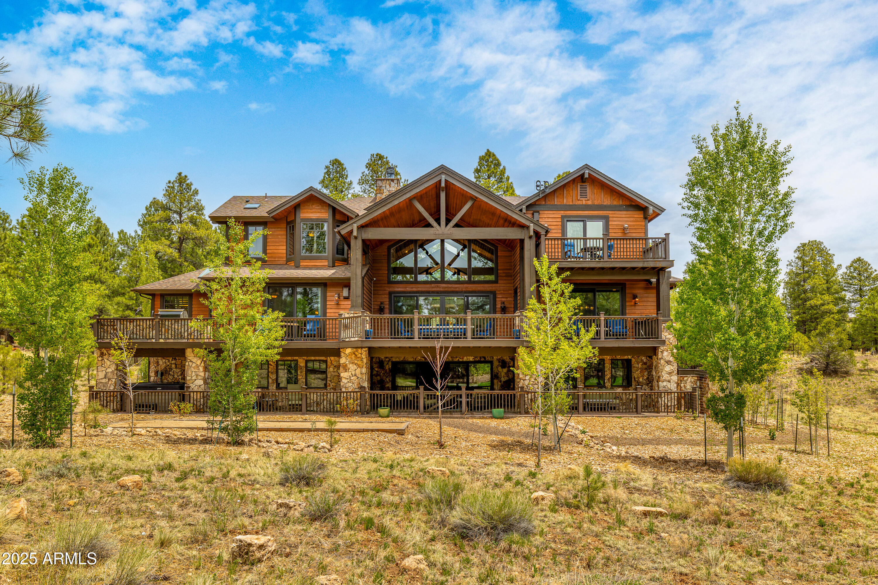 Welcome to your mountain escape—where luxury meets livability in one of Pine Canyon's most spectacular homes. With 8,698 sq. ft., 7 bedrooms, 7 full bathrooms, and 2 half baths, this expansive estate is perfectly designed for large families, entertaining, and multi-generational living. Step inside to soaring vaulted ceilings, exposed wood beams, and a floor-to-ceiling stone fireplace that anchors the grand living room. Built-in cabinetry and an entertainment center make this the heart of the home. The adjacent chef's kitchen is a showstopper, featuring a massive island with bar seating, 6-burner range with griddle, custom metal hood, double ovens, full backsplash, and a commercial-sized refrigeratoreverything you need to feed a crowd or host a gourmet dinner party. Tucked nearby: a walk-in pantry, office nook, and formal dining space.
Step out onto the wraparound deck and take in breathtaking views of the 12th fairway, surrounded by towering Ponderosa pines. This outdoor space connects seamlessly to the living room, dining room, and master suite, offering indoor-outdoor living at its best.
The main-level primary suite is a serene sanctuary, complete with a fireplace, sitting area, exposed beams, and a private passage to the lower level through the walk-in closet. The spa-inspired bath features dual vanities, a jacuzzi tub, and an oversized walk-in shower. Two additional en-suite guest rooms are also located on the main floor for ultimate convenience.
Downstairs, the walk-out basement is a world of its ownoffering two spacious family rooms, a home theater with stadium seating, game/card space, ample storage, and two more en-suite bedrooms, one with patio access.
The third level adds even more flexibility, with a cozy loft, two en-suite bunk rooms each with 4 built-in bunks, a third family room with a fireplace, and a private upper deckperfect for kids, guests, or casual hangouts.
Whether you're hosting a family reunion, entertaining friends, or simply relaxing in the beauty of Northern Arizona, this extraordinary home delivers room to breathe, views to remember, and craftsmanship to admire.