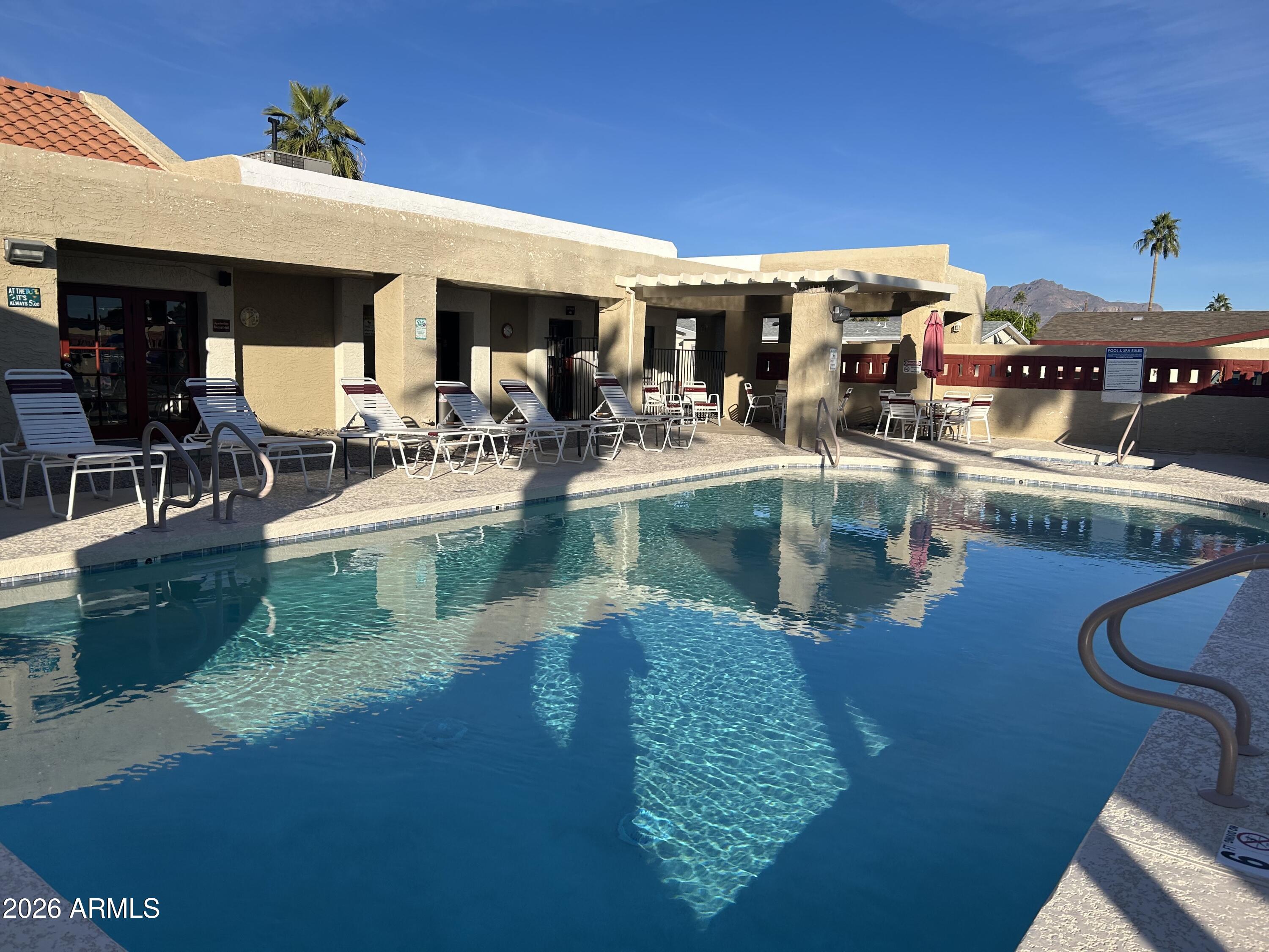 Enjoy the sunshine and a carefree life in this gated 55+ community. Many, tastefully done upgrades to this unit in 2023! This ground set unit has elegant cement work and landing allowing easy access. It offers a bright and airy open plan. The kitchen has a butcher block island with ample storage; dining is just off the kitchen with open access to the living room. All appliances are included. There is attractive laminate and vinyl flooring throughout. The master is large and provides closet organizers, dual sinks, and a walk-in shower in the master bath. It has a handy utility area that includes the washer and dryer. Savor out/door living in the screened in AZ room. Exterior is repainted with a modern pallet for an attractive curb appeal. The yard is fenced to keep your animals safe and has a handy, large BONUS storage shed. The main shed is attached to be used for hobbies, or more storage. You are invited to take part in community indoor events at the clubhouse (meals, game nights, etc) or outdoor activities at pool side, bocce ball and shuffleboard. The open desert is just minutes away with ample hiking trails for all fitness levels.  This unit has it all; so, take a look at it today!