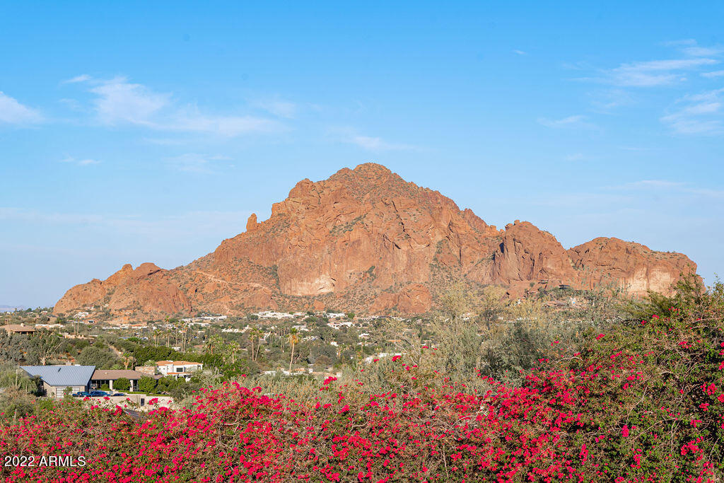 Welcome to 6112 North Paradise View Drive in beautiful Paradise Valley, Arizona.  On almost 6 acres, this grand estate features breath-taking 360-degree views which include Camelback Mountain and the iconic Praying Monk, the Phoenix Mountain Preserve, and South Mountain.  Originally built in 1967 for Penzoil heir, Walter McCune, the mansion came to be known as the McCune Mansion.  Sparing no expense, the opulent structure was designed to feature native Arizona stonework on the exterior.  Inside, imported marble and tile as well as a stunning amethyst stone fireplace are examples of the bespoke details featured in the original construction. 
Features include both a guard house and a gate house; an Olympic sized swimming pool, his and hers locker rooms; what was a movie theater and a ballro There are 12 bedrooms and 12 baths, a separate 2,900 square foot guest house, and a multi-million dollar retaining wall. In total there are 52,000 square feet of livable square footage (to be verified by buyer).  
The mansion sits on a 3.77-acre lot and there are two adjoining parcels of raw land bringing the total lot size to 5.97 acres.  This is an investment opportunity of a lifetime to renovate the existing structure or develop the acreage.   There is no better location in Paradise Valley with easy proximity to downtown Phoenix and all its offerings from the arts and museums, to sporting events, restaurants, and the ASU downtown campus.  Just 15 minutes to Sky Harbor international airport, commuting is a breeze.