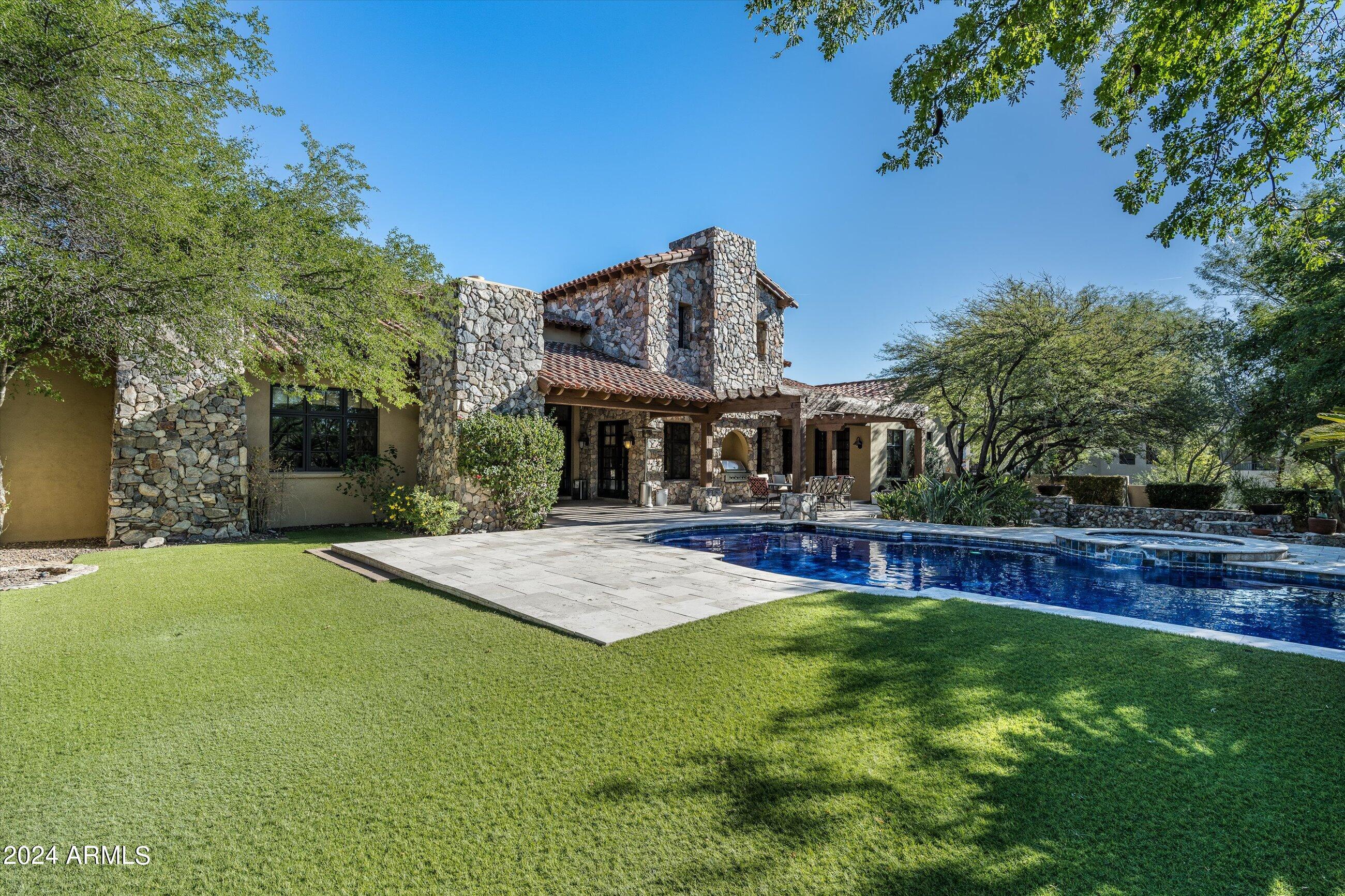 Esteemed location in Silverleaf, desirably located in the Windgate Pass guard gate this stunning custom ranch estate is beaming with charm and character.  Architecturally striking curb appeal with welcoming grass front yard with spacious entertaining courtyard with fireplace and covered porch entry. Well-designed home plan offers functionality and sophistication, with the great room as the heart of the home anchored with a grand stone fireplace with soaring wood beam lined ceilings and wrap around wet bar, spacious secondary ensuite bedrooms, executive office and plus den with dual access to great room and secondary bedroom wing, this gem offers optimal living experiences.  Inviting kitchen oversized eat in island opens to front covered porch convenient for relaxing and unwinding, or perfect for social gatherings in front courtyard.  

Refined style, with impressive details woven throughout including wood accented ceilings with beams, tongue/groove, coffered, and brick features, stone and wood flooring, and wood window shutters.  Enchanting backyard boasts Sonoran Mountain views featuring heated pool and spa with lounging hardscape, expansive covered patio with fireplace, built-in BBQ and ramada for entertaining, firepit with sitting area, and generous turfed grass area.  Sought after location, conveniently located near neighborhood parks and lake, this ranch one story with no stairs or step downs will impressive the most discerning clients.