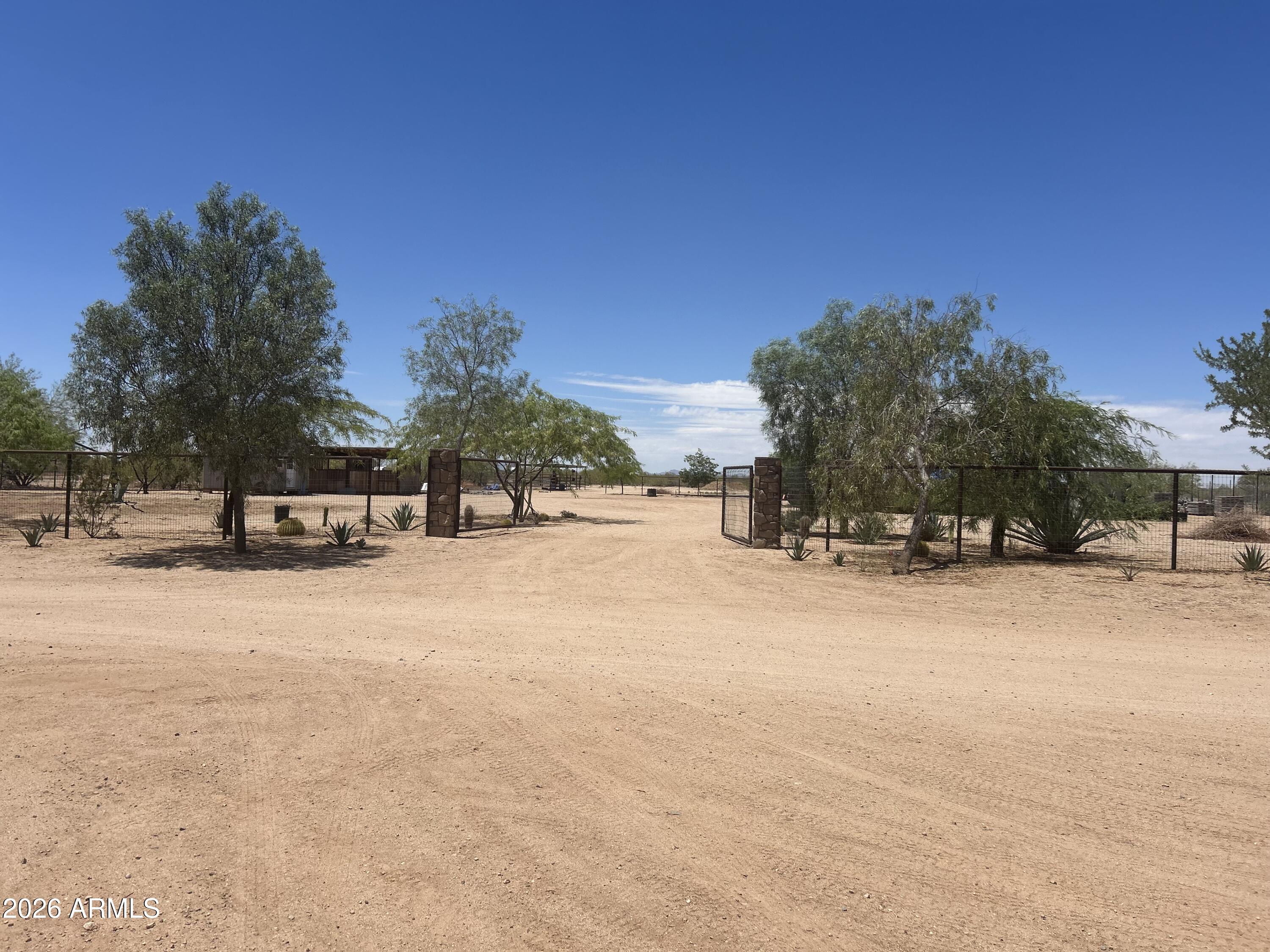 Bring your dreams and plans to this growing area of Wittmann. Great opportunity to own this flat, cleared 2.86 acres. Put your finishing touches on the casita. Land comes with 2 horse corral/sheds. Desert landscape with irrigation lines already completed, with several irrigated trees. Don't miss the opportunity.