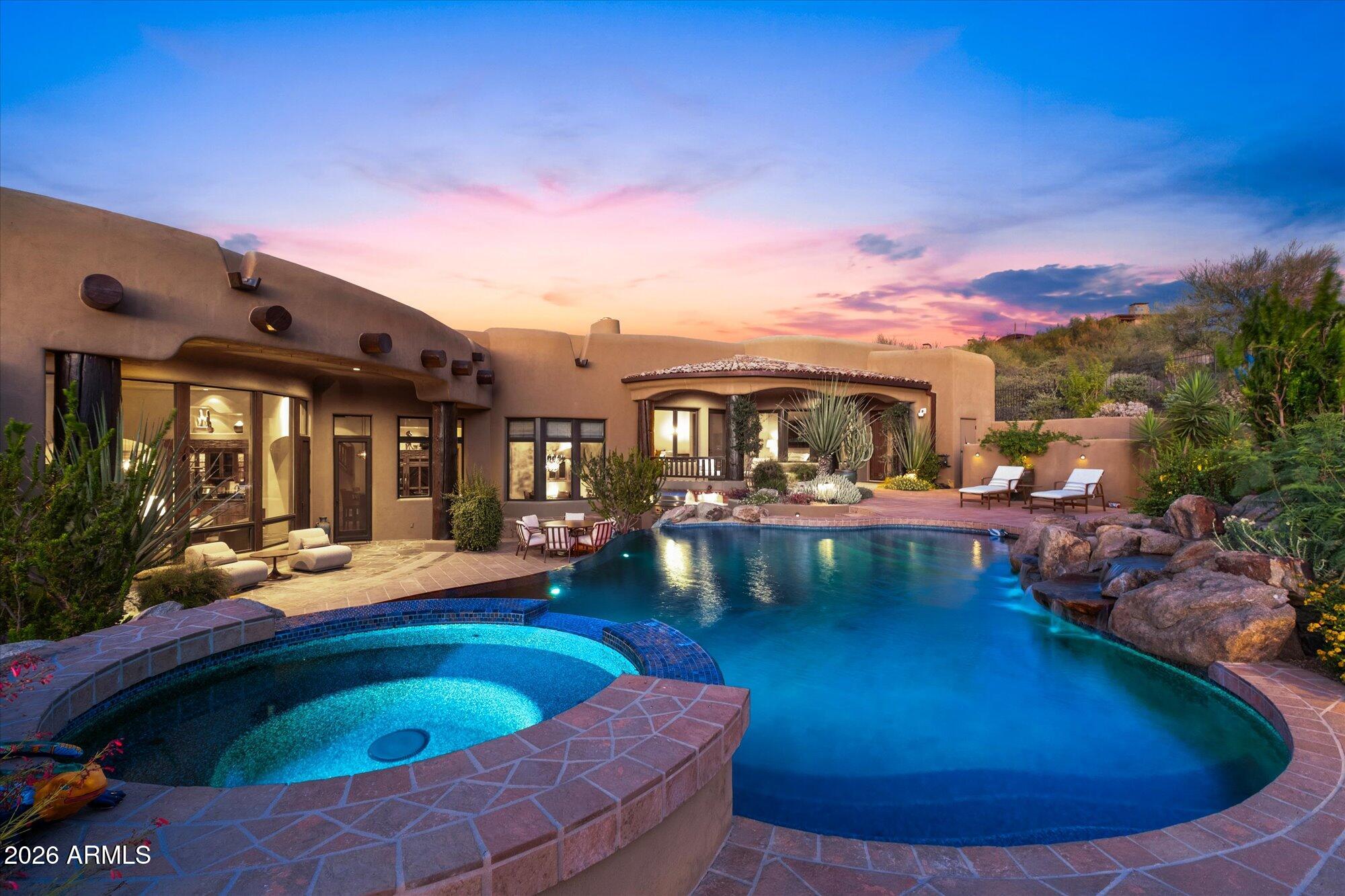 Rarely does a home combine architectural character, panoramic mountain and desert views, and a Troon setting like this. Set among Scottsdale's iconic granite boulders in the prestigious guard-gated Troon community, this custom RS Homes estate features wood-beam and plank ceilings, slate floors, and custom detailing throughout. The main level includes the primary suite, attached casita with a private entrance, kitchen, great room, and guest bedroom. Just a few steps up are the office with a closet and ensuite bath, ideal as a 4th bedroom, and a separate home gym. Wine cellar, negative-edge pool, spa, waterfall, Crestron smart-home technology, 3-car garage with storage, complete privacy, panoramic front and rear views, Arizona sunsets, and minutes to Troon Country Club.