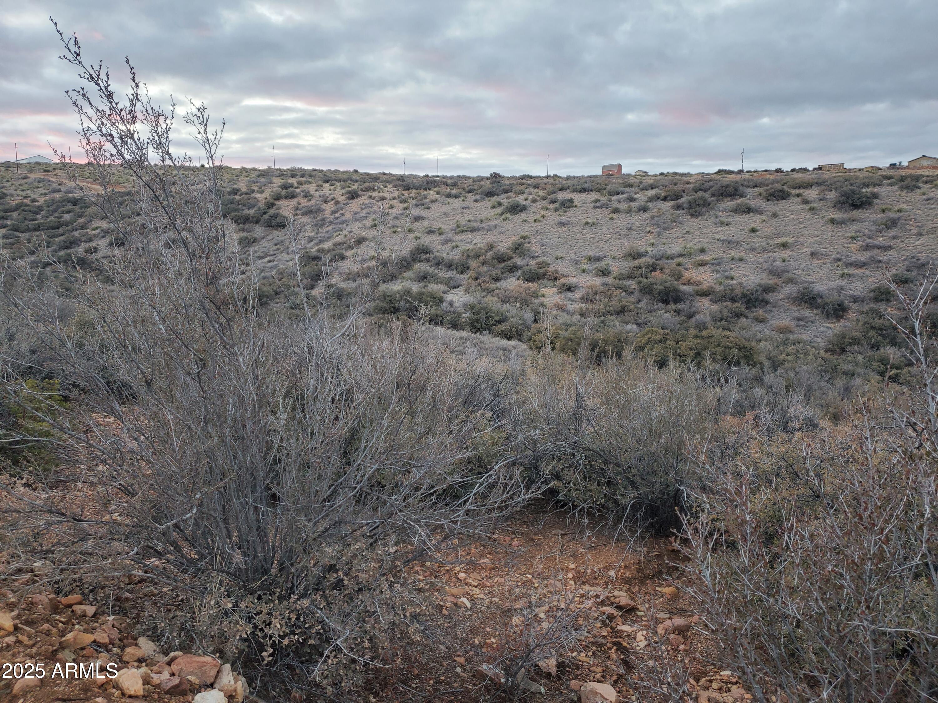 Nestled between two scenic hillsides in the desirable Blue Hills Farm Subdivision of Dewey, Arizona, this 2.14-acre parcel offers the perfect blend of privacy,
 natural beauty, and development potential. Surrounded by the quiet charm of Arizona's high desert landscape, the property sits in a lower elevation area, yet still provides sweeping views of the surrounding terrain. Whether you're planning to build a custom site-built home or install a manufactured home, this land presents a versatile canvas to create your ideal retreat. With plenty of open space, gentle topography, and the backdrop of rugged hills, it's an excellent opportunity for those seeking peaceful living with expansive vistas. This parcel is truly a hidden gem for anyone looking to embrace the Arizona lifestyle.