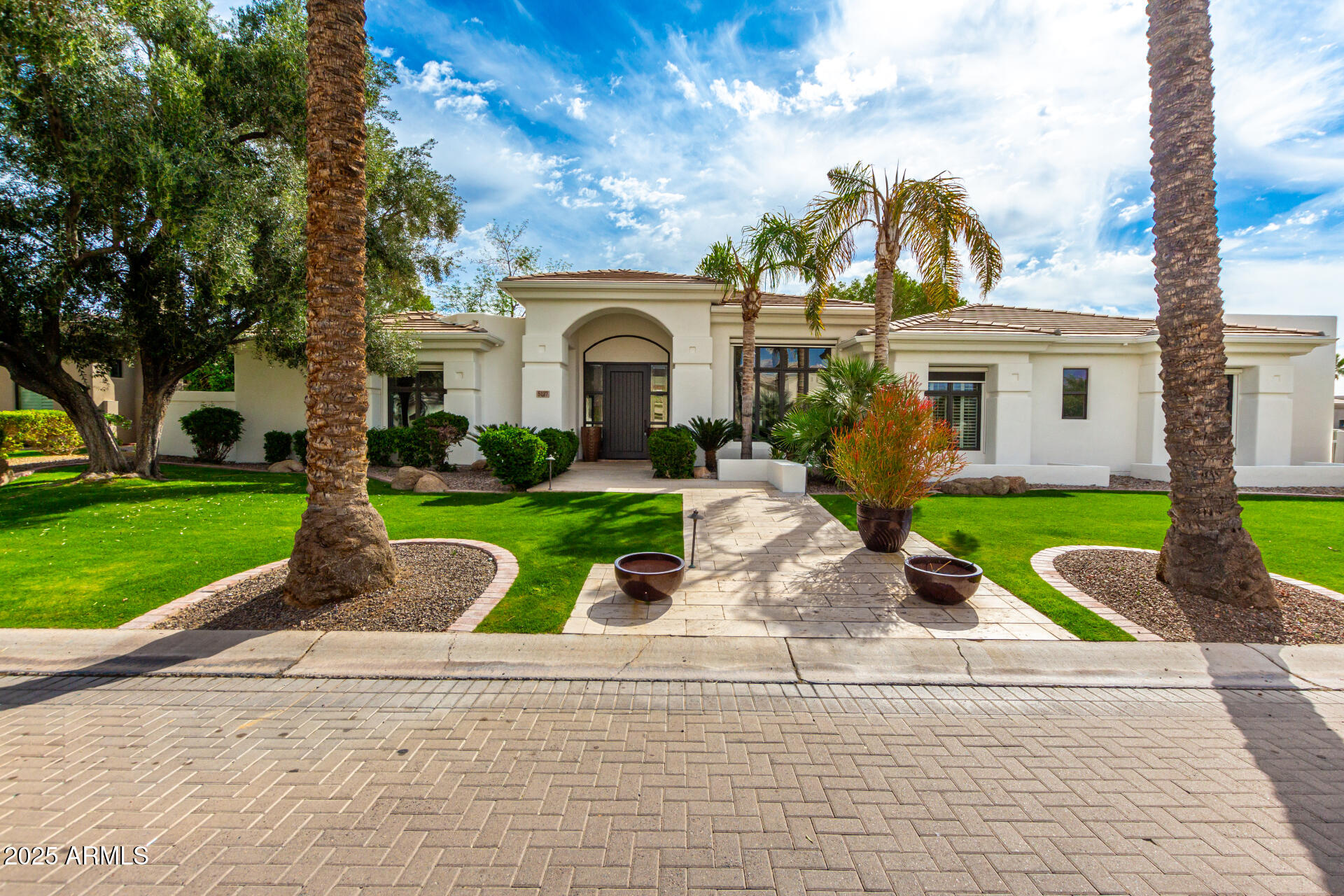 Pristine and lush, this completely remodeled home is located in the exclusive gated neighborhood of Via Vista, surrounded by mature vegetation and iconic palm trees. Inside, soaring ceilings and floor-to-ceiling windows flood the space with natural light, framing views of the sparkling pool and resort-style backyard.

The home features a flexible split floor plan, including a full downstairs suite with a guest bedroom, flex space, kitchenette, and private entrance—ideal for guests, extended family, or a home office. The chef's kitchen is outfitted with high-end appliances and finishes, opening to a warm, inviting living room that flows seamlessly to the meticulously landscaped backyard.

A serene water feature cascades into the play pool, creating a peaceful centerpiece that offers total privacy and tranquility. Upstairs, the spacious primary suite includes a cozy fireplace and a spa-like bath with a soaking tub, glass shower, and dual vanities. Each secondary bedroom includes its own en suite bath. Home comes equipped with Sauna and Steam Shower.
Tucked in Paradise Valley and just minutes from the best of Scottsdaledining, shopping, golf, and morethis home delivers elegance, flexibility, and the perfect Arizona lifestyle.
