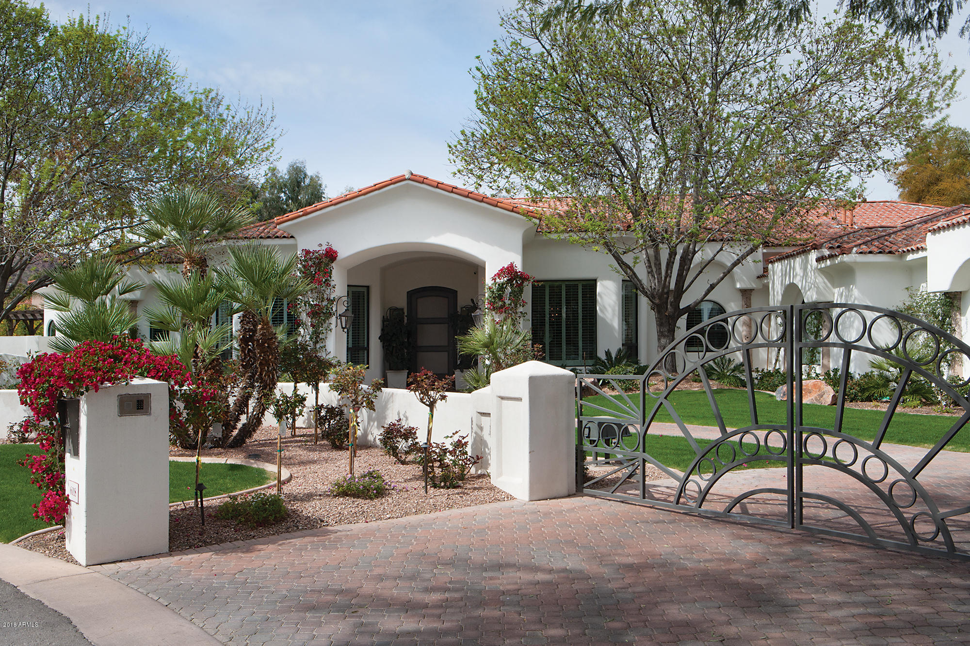 Beautiful Santa Barbara style home with over 7000 square feet in a quiet cul-de-sac in Paradise Valley. The main house consists of 4 ensuite bedrooms, gorgeous office with bathroom, 4 car oversized garage, exercise room and extra large master closet. Generous sized kitchen which overlooks the family room and walls of windows to the backyard.  There is a wonderful guest house with full kitchen and close to 800 square feet. Backyard is very private with oversized pool and has gorgeous views of Camelback mountain.