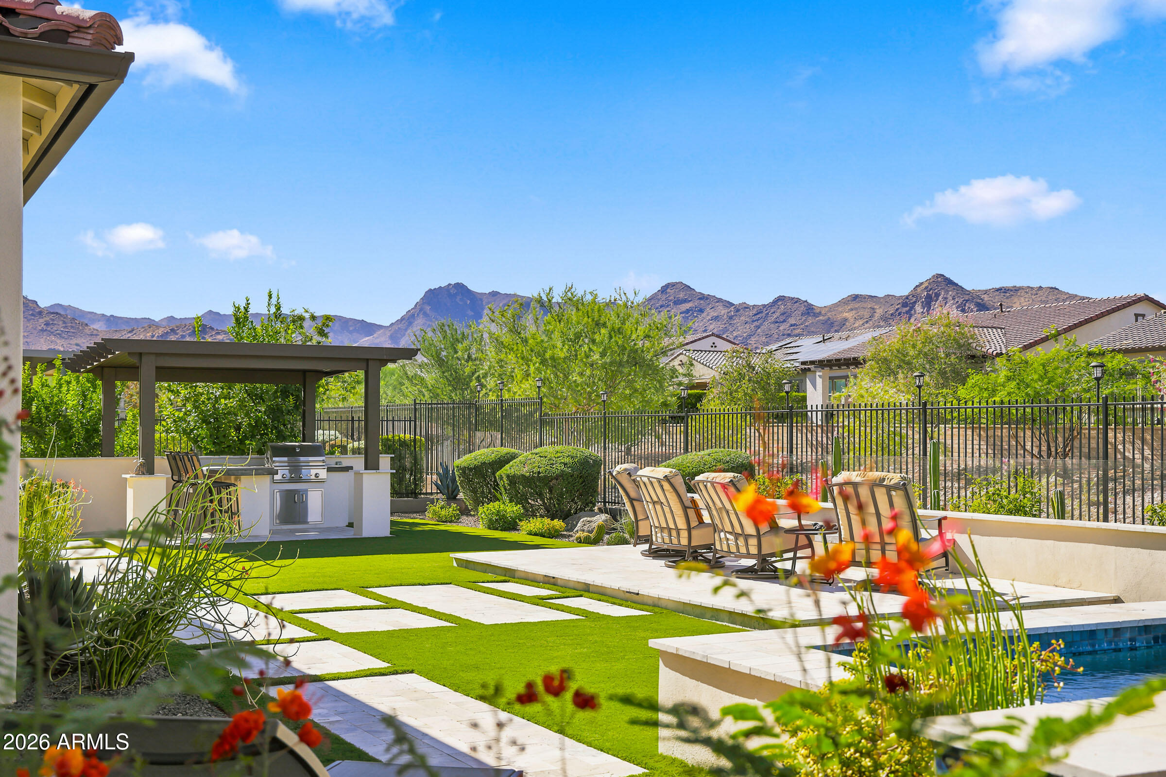 BEAUTIFUL MOUNTAIN VIEWS from pristine backyard w/view fence to community space & walking path. Popular David Weekley Serendipity floor plan, meticulously upgraded and move-in ready! Inviting front courtyard w/new decorative security screen door opens to a stunning great room with custom beam ceilings and designer finishes. Chef's kitchen features honed Monte Cristo granite, an oversized butler's pantry, and two wine refrigerators. Beautiful neutral décor, new window coverings, new front landscaping, wood flooring in the primary suite and both guest suites. Spacious primary retreat offers patio access, a spa-like bath, and custom closet organizer. Expanded covered patio, oversized spa, elevated fire pit, outdoor kitchen-- Experience Victory living at its finest!