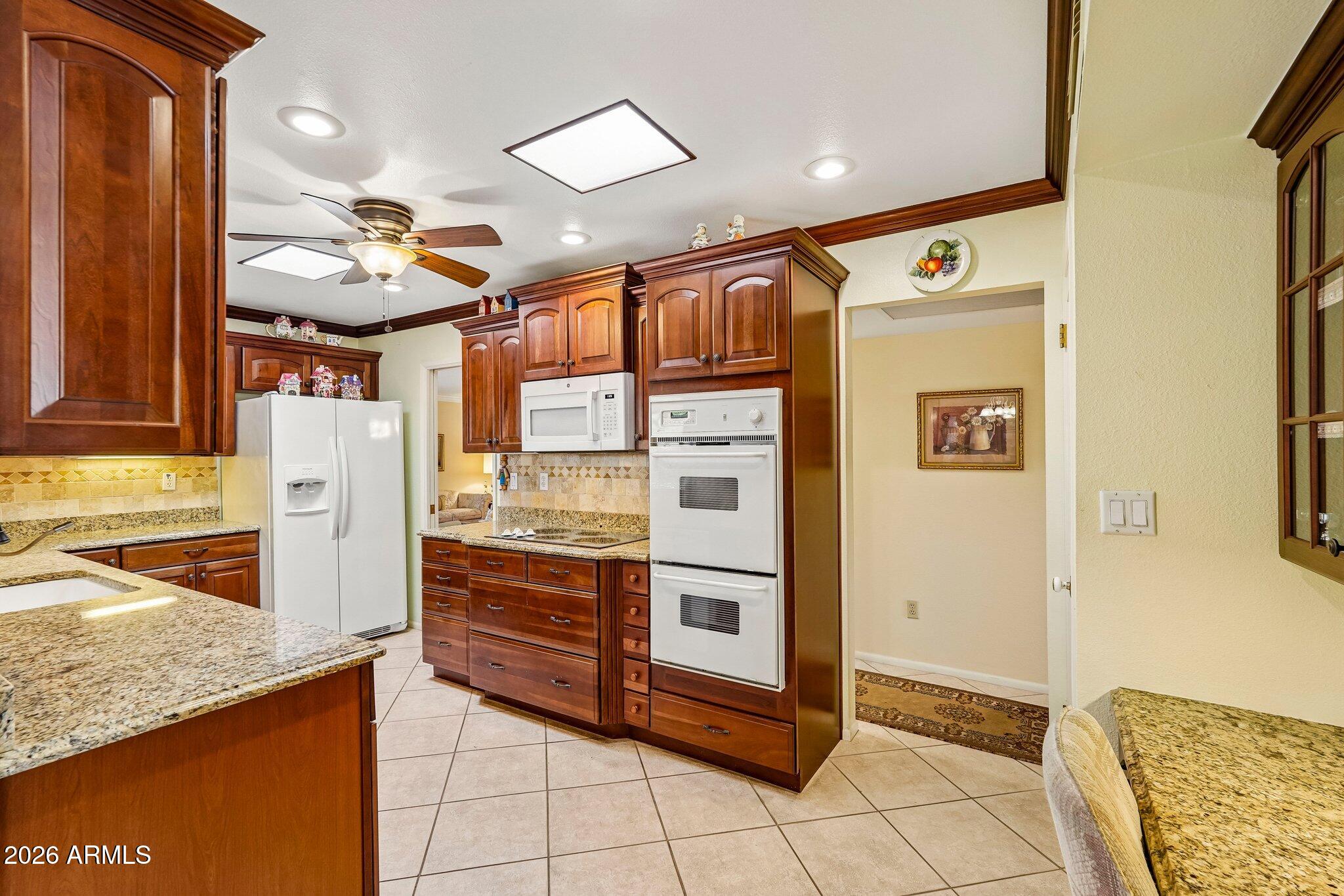 Perfectly positioned on a desirable golf course lot, this expanded Sun City home offers the ideal blend of comfort, style, and scenic views. A designer front door welcomes you inside, where plantation shutters and an updated kitchen with custom cabinetry add timeless appeal. The thoughtfully expanded floor plan provides versatile living space perfect for entertaining, hobbies, a home office, or everyday living. Relax on the misted patio while enjoying peaceful golf course views year-round. Ideally located near recreation centers, golf courses, shopping, dining, medical facilities, and all of Sun City's renowned amenities, this well-maintained home offers the best of Arizona's active adult lifestyle.