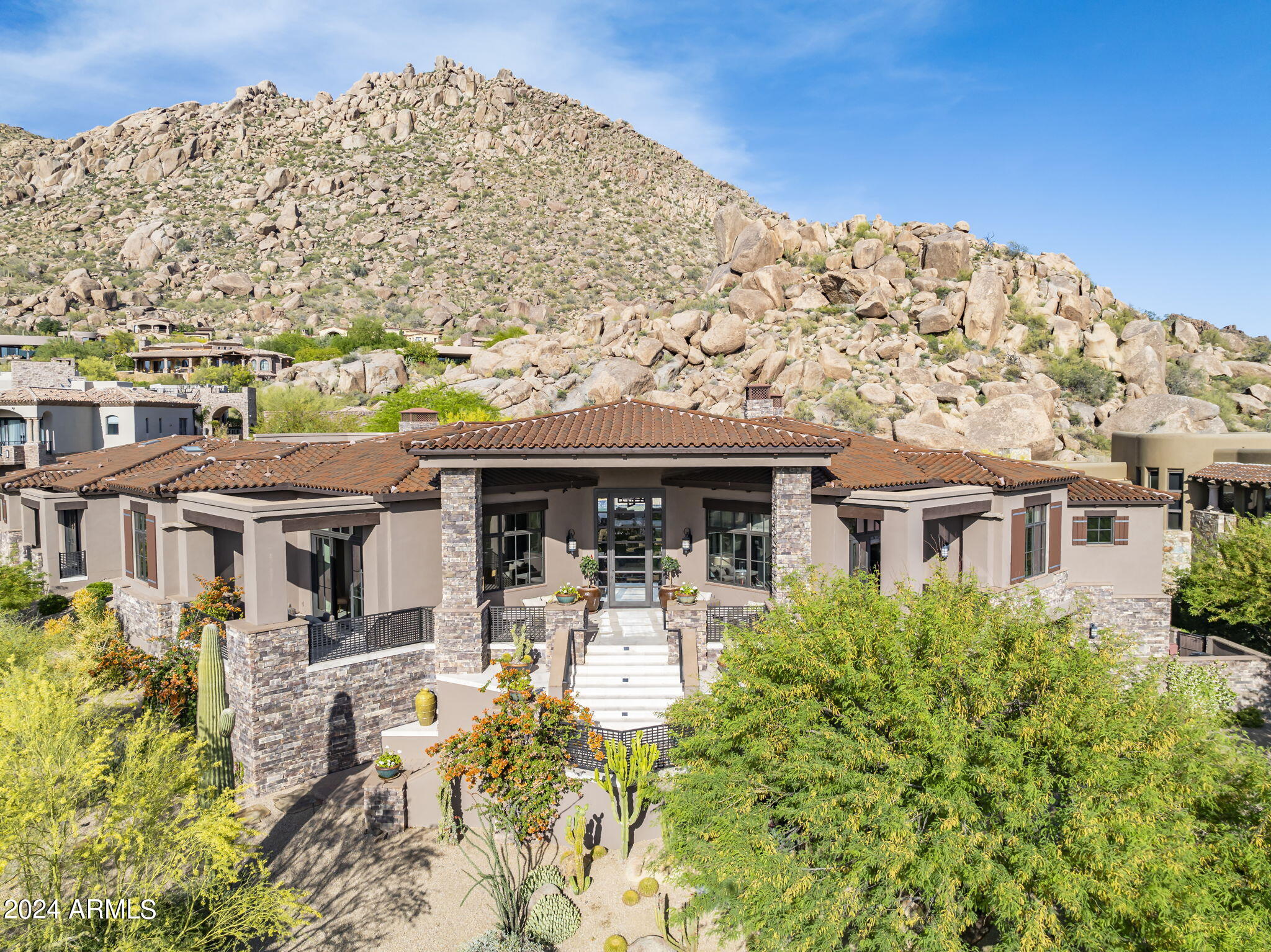 Absolutely Jewel of a house, priced to sell!!!  No Way can this be duplicated for even close to this price.   This contemporary Southwest masterpiece, designed by Tor Barstad and completed in late 2015, spans 8,382 square feet. Situated on a prime lot, the home boasts panoramic views capturing stunning sunsets, Pinnacle Peak, and dramatic boulder landscapes. The owners have meticulously refined every detail, from custom window treatments and mature landscaping to perfecting the outdoor living spaces and addressing all new home adjustments, ensuring that this house is the epitome of move-in ready.
The residence features an expansive open floor plan that includes five bedrooms, an office, an exercise room, and a bonus room, with nearly all living space A highlight is the fully-equipped bakery adjacent to the kitchen, which also features an oversized bar, a large wine cabinet, and expansive pocket doors that enhance the flow between the great room and kitchen.
The designer kitchen is a culinary dream, equipped with four ovens (including LaCornue Chateau and Viking), multiple Sub-Zero refrigerators and freezers, two Viking microwaves, dishwashers by Asko and Fischer & Paykel, two Scotsman icemakers, and a Wolf warming drawer. The home's interiors are both modern and inviting, with light finishes, limestone and wide-plank wood floors, granite and marble countertops, and custom details such as brick and wood ceiling treatments, bespoke plumbing fixtures, lighting, and a comprehensive house-wide audio/visual system.
The backyard is an entertainer's paradise, featuring a large pool and spa, three fire elements, an outdoor BBQ center with a spacious island, multiple covered patios, and even an outdoor pool shower and bathroomall set against the backdrop of Troon's iconic rock formations. This private, guard-gated community is just moments from the Troon Country Club and only ten minutes from the Loop 101, blending exquisite privacy with convenience.