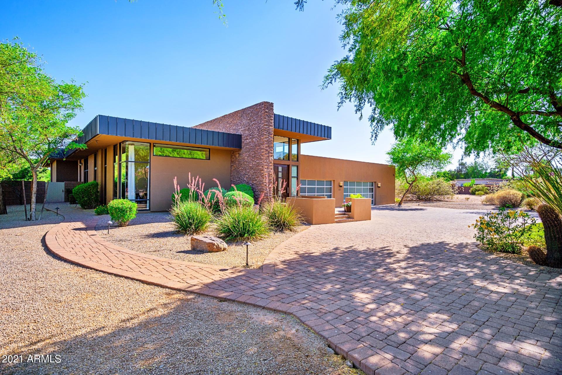 Live, work and entertain in this incredible desert contemporary home on a one acre lot in the heart of the Cactus Corridor!  Architectural masterpiece on a perfectly spacious and balanced floor plan ideal for year round indoor and outdoor living.  Striking finishes throughout include hardwood floors, disappearing walls of glass, expansive media space complete with a separate theater room, lap pool, multiple water features, separate firepit/cigar area, RV parking, gorgeous guesthouse which includes a kitchen, bathroom and family room;  the list goes on!  This home boasts exceptional natural light and storage throughout with a remarkable backyard paradise. The expansive backyard features a sparkling pebble tec lap pool and spa with a swim up bar and is surrounded by multiple fire features and several patios to entertain. Top of the line WOLF kitchen appliances, a walk in pantry, laundry room and 3 sub zero wine fridges complement everyday living.  En suite bathrooms, large open master suite with floor to ceiling walls of glass, electric shades in every room, built in patio heaters, 6 fire features, patio misters, a dedicated office, 4 car garage with multiple storage closets  all within proximity to the highlights of everything Scottsdale has to offer.  Boasting an array of stunning finishes coupled with soaring 11' and 15' ceilings throughout  this home is truly extraordinary.