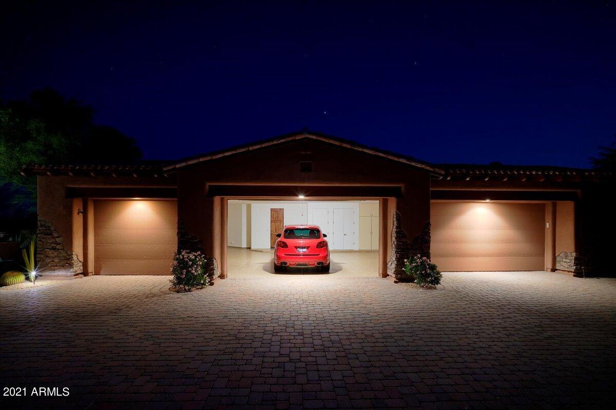 Homes4CarGuys brings you this amazing home high up in the gated Rolling Hills section of Sonoran Crest with close up mountain views front and back.  Bring your cars and toys, this home has a rare oversized 6 Car Garage that features one extra deep bay. The large split design has No Steps and an attached guest house with full kitchen. You'll love the massive kitchen that opens up into a wet bar, breakfast nook, a warm family room with stone fireplace and big mountain views! As you'd expect this home is full of Subzero and Wolf appliances. It is ready to entertain inside or out with a play turf section and custom BBQ area. You'll be mesmerized by the views while lounging in the gorgeous custom pool and spa with tranquil water and fire features.