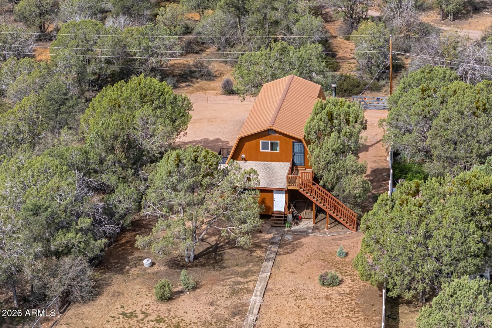Discover this incredible 1.01+/- acre private horse property bordering the US National Forest, offering unmatched serenity and directaccess to nature. This unique 1920+/- sq ft red barn style home features 3 bedrooms and 2 bathrooms, along with a separate exterior staircase and deck providing private access to the upper level - ideal for flexible living arrangements. The property includes a private well and boasts a distinctive all-copper roof,complemented by fresh exterior paint. A spacious basement offers abundant storage or potential for additional use. Enjoy peaceful mornings on the inviting front porch, where you can take in frequent wildlife sightings, like javelinas and elk, as they roam the neighboring National Forest.