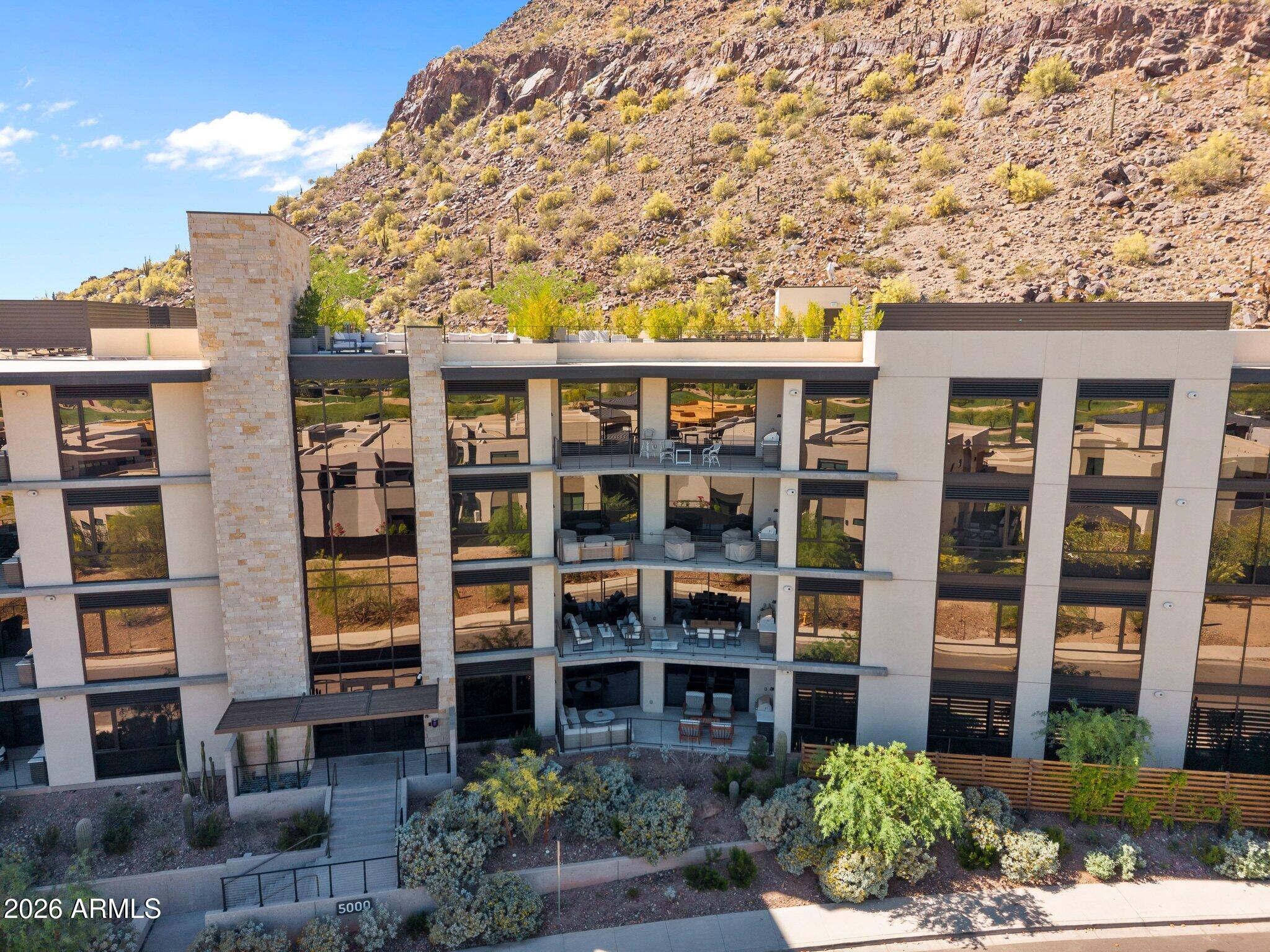 Tucked at the base of revered Camelback Mountain, this exceptional residence in the exclusive guard-gated community of Ascent at The Phoenician offers a rare combination of modern design, privacy, and effortless resort living. Set within one of Scottsdale's most coveted enclaves - where Arcadia, Scottsdale, and Paradise Valley meet - and adjacent to The Phoenician Resort, Ascent was thoughtfully envisioned by Nelsen Architects with interiors by Vallone Interior Design, seamlessly integrating the natural beauty of the Sonoran Desert into its contemporary architecture. Residence #208 is filled with natural light, featuring expansive glass, 10-foot ceilings, and a refined palette of warm, modern finishes. Thoughtfully designed with a clean, timeless aesthetic, the interiors offer a sophisticated backdrop that feels both current and enduring. At the heart of the home, a beautifully upgraded Bulthaup kitchen showcases clean European design, Sub-Zero and Wolf appliances, and an oversized island that anchors the living space.

The great room opens to a generous private terrace, where wide-open sky and striking mountain views create a peaceful connection to the surrounding landscape--an ideal setting for both quiet mornings and relaxed evenings.

The primary suite offers a tranquil retreat with a spa-inspired bath and generous walk-in closet, while a well-appointed secondary bedroom and separate den/office provide flexibility for guests, remote work, or additional living space.

Residents enjoy access to resort-style amenities including a heated pool and spa, fitness center, and elegant gathering spaces--all just moments from The Phoenician, Old Town Scottsdale, and the premier dining and shopping of Arcadia and the Biltmore area.

A refined lock-and-leave opportunity in one of the Valley's most sought-after luxury communities.