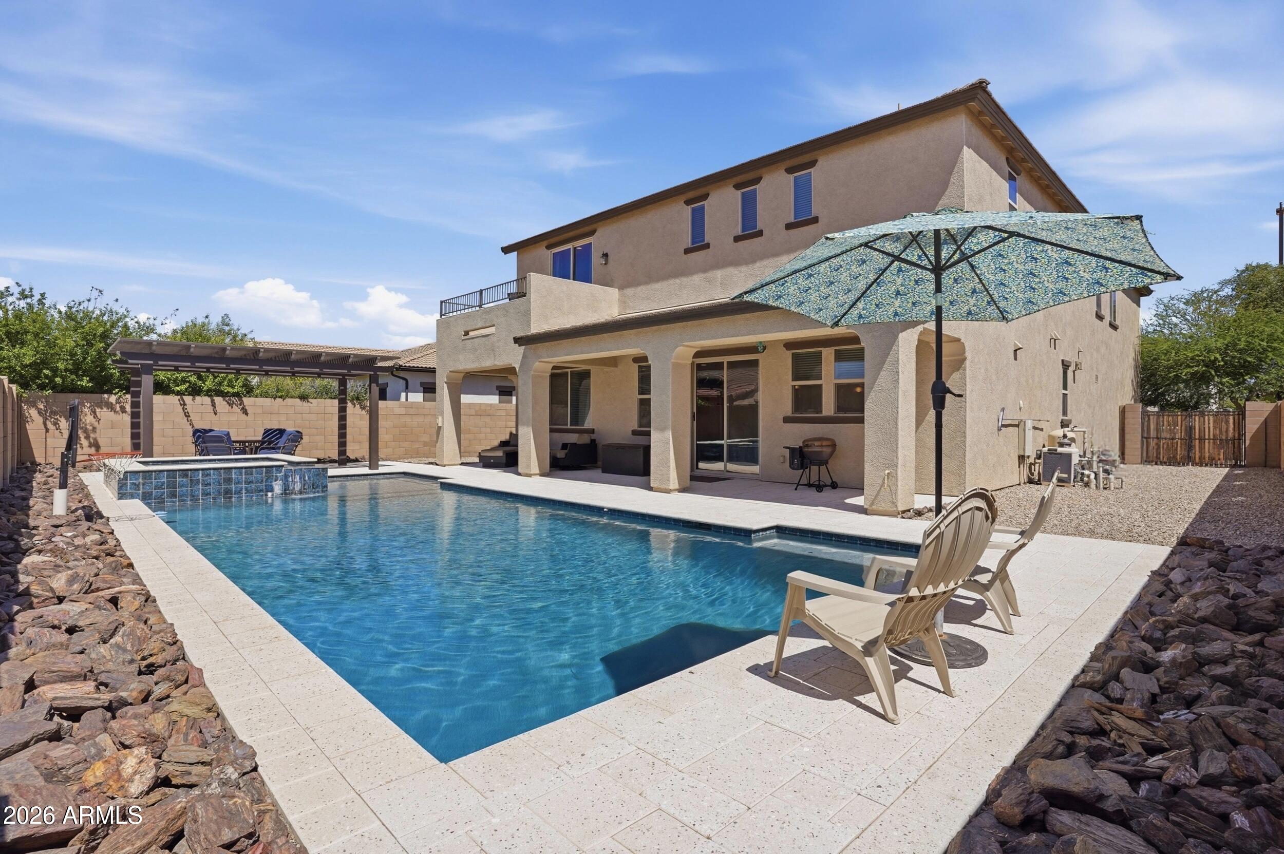 Welcome to Legend Ridge, a quaint gated community off the Val Vista Corridor located directly adjacent to the Perry High School campus. Step outback to experience this home's attention-getter, the resort-style heated pool and spa built by Presidential Pools, complete with a baja step, over-flowing water feature, and a brand-new Pentair control panel for easy mobile app operation. Beautiful, white pool coping and decking from Artistic Paver Mfg. surround the pool and patio areas. The Alumawood pergola is strategically placed to provide afternoon and early evening shade over the baja step and spa. At the front of the home, an attached casita with its own entrance is perfect for an office space, exercise room, or guest room. The main floor consists of an entry way lined with diagonal tile floors and inlays, as well two living areas, one with a stone gas fireplace and formal dining area, and the other adjacent to the kitchen features beautiful wood flooring. The over-sized kitchen features upgraded, staggered cabinets with glass-front corner cabinets, crown molding, granite countertops, stainless steel appliances, and a butler's pantry complete with a sink and wine fridge. The second floor has three en suite bedrooms, built-in cabinets and bookshelves in the hallway, and a loft space that could easily be converted to an additional bedroom. The primary suite has its own private balcony great for morning coffee, sunset watching, and a view of the San Tan Mountains. Its huge bathroom is highly-upgraded with Travertine tile, a tiled shower and separate garden tub, dual vanities, and two walk-in closets. Additional highlights include a three-car tandem garage with epoxy floors and a large storage closet, RV gate, and low-maintenance landscaping. Located in the highly-rated Chandler School District near shopping, restaurants, parks, the 202 San Tan Freeway, and a brand-new Life Time Fitness less than a mile away, this home and neighborhood are hard to beat!