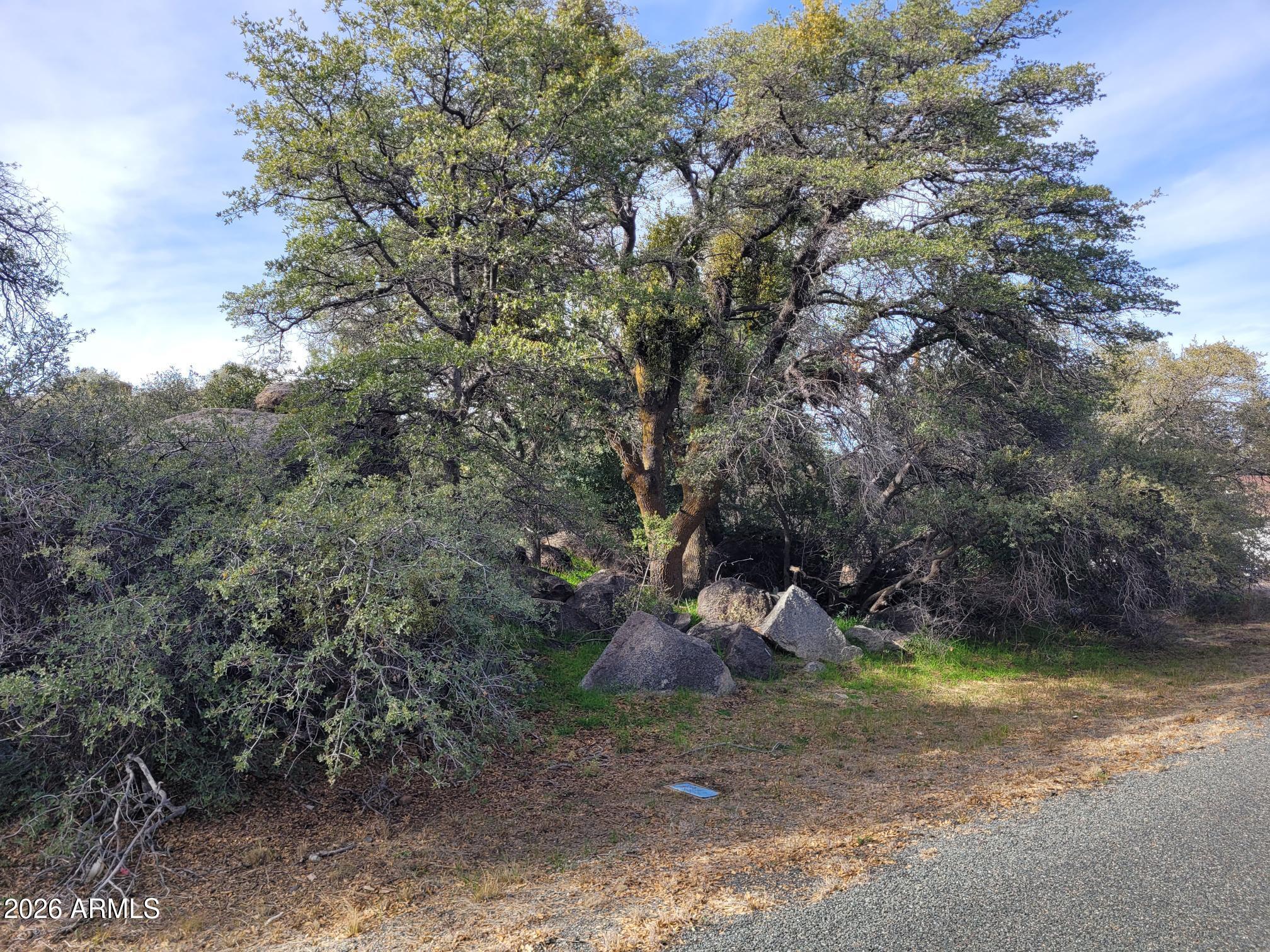 Discover this unique 2.32-acre property located just off a paved road, offering convenient access to both water and power. This listing includes four parcels (APNs: 203-14-140L - 1.83 acres, 203-14-130A - 0.07 acres, 203-14-139 - 0.01 acres, and 203-14-126 - 0.41 acres), totaling 2.32 acres per county assessor records. The land features mature trees, striking boulder formations, and breathtaking panoramic mountain views--an ideal setting for your custom site-built home. Zoning allows for site-built homes only; manufactured homes are not permitted. Enjoy the freedom of NO HOA! One parcel (#203-14-126) includes an old foundation. County records indicate a conventional septic application; however, the seller has no information regarding installation, location, or condition of the septic...... system. Property can be accessed from Mountainaire Dr or Barker Way. Buyer to verify all utilities, zoning, and property details. Please refer to the Documents tab for additional information.