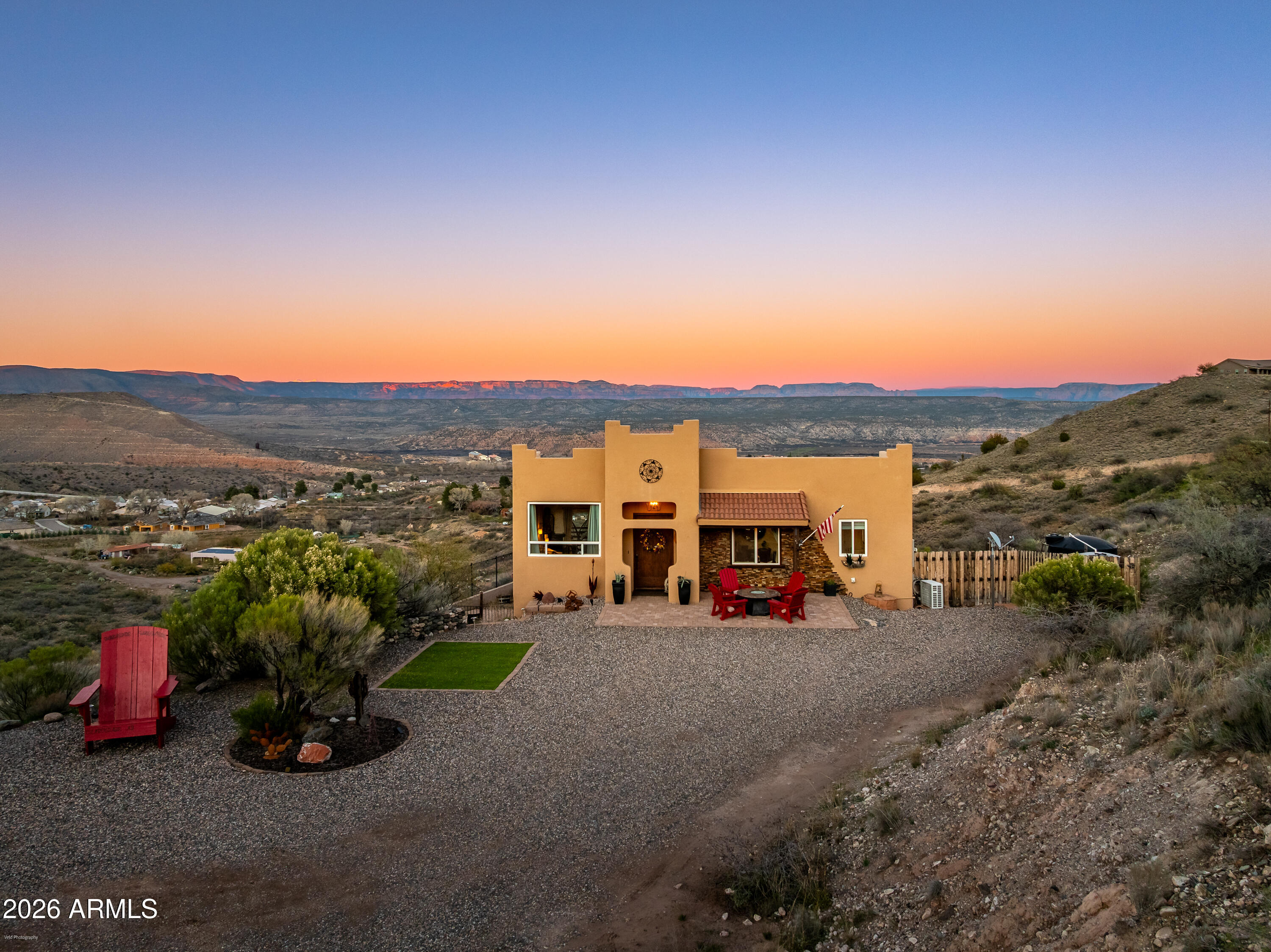 This one-of-a-kind, solidly constructed hillside home overlooks historic Clarkdale and offers unobstructed, panoramic views of the Verde Valley. Situated on 2+ acres with no HOA. The property features steel 2x4 and 2x6 framing and a durable metal roof. The main residence provides two levels of living space with four bedrooms, two living areas, and two dining spaces. The well-appointed kitchen includes gourmet features and an espresso bar. Additional highlights include a wine cellar, an expansive fenced lower-level outdoor living area, and an upper balcony designed to capture the valley's most commanding views. The bonus detached shed/casita 12x24 offers a private driveway, a full bath, and a kitchenette. Storage shed 12x30. The home is being sold furnished as shown (excluding wine and select storage items), making it a turnkey second home, vacation retreat, or income property.

Recent updates include fresh paint, a newer HVAC/heat pump, and updated windows, cooktop, flooring, and washer.

Ideally located just minutes from the historic town of Jerome, the Clarkdale Copper Museum, local parks, shops, and restaurants. It is also a short drive to the Verde Canyon Railroad and other premier Sedona/Verde Valley attractions.