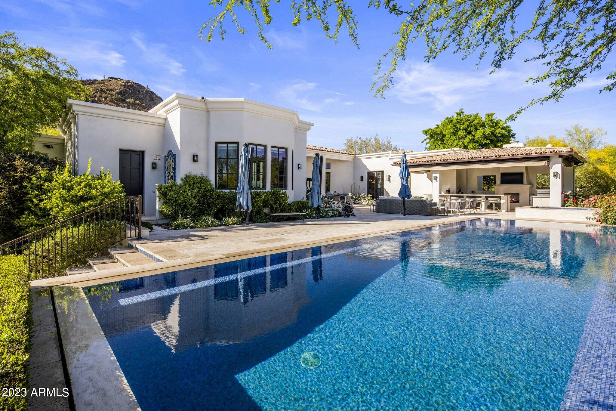Stop looking; you've found your dream home! This completely remodeled, one of a kind modern estate is sure to impress with its designer finishes and stylish flare, while still maintaining a luxurious Arizona feel. Walking through the entry path, hearing the trickle of the water feature and staring directly at Camelback Mountain, your jaw will hit the ground. Tall ceilings and a collapsing wall, perfectly frame Camelback Mountain. With 4 en-suite guest bedrooms, a stunning primary suite, plus a bonus room that would be ideal for office or play room there is plenty of space for everyone. Primary suite is a slice of heaven with cozy fireplace, sitting area, oversized bathroom and not just one, but two, oversized walk-in boutique clothing closets. A gourmet kitchen that looks like it belongs on the cover of a magazine and features eat-in island, Wolf range, SubZero and a full beverage station (coffee bar or wine ... depends on the time of day). Tranquil backyard with infinity edge pool, outdoor kitchen and a putting green. Don't wait or else you may miss it!