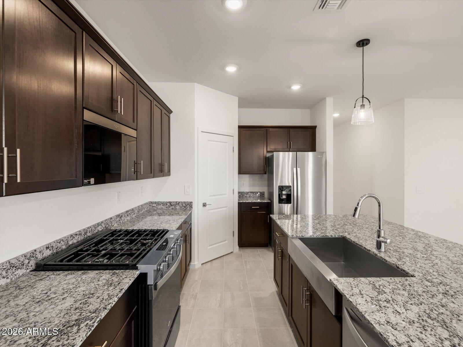 Popular Mason floor plan in the desirable Entrada community in Tolleson. This single-story home features an open-concept layout with a spacious great room, modern kitchen with island, and a private primary suite with walk-in closet. Upgrades include dark umber cabinets with hardware, granite countertops, and extensive tile flooring complement this spacious plan. Meritage homes are move-in ready with included washer, dryer, refrigerator, and window blinds, plus closing in 60 days or less guaranteed. Future community amenities will include a clubhouse and pool, ideal for easy living and entertaining. Residents will enjoy homes featuring flex spaces, covered back patios, secluded primary suites and more. Each of our homes is energy-efficient construction while providing comfort and savings.