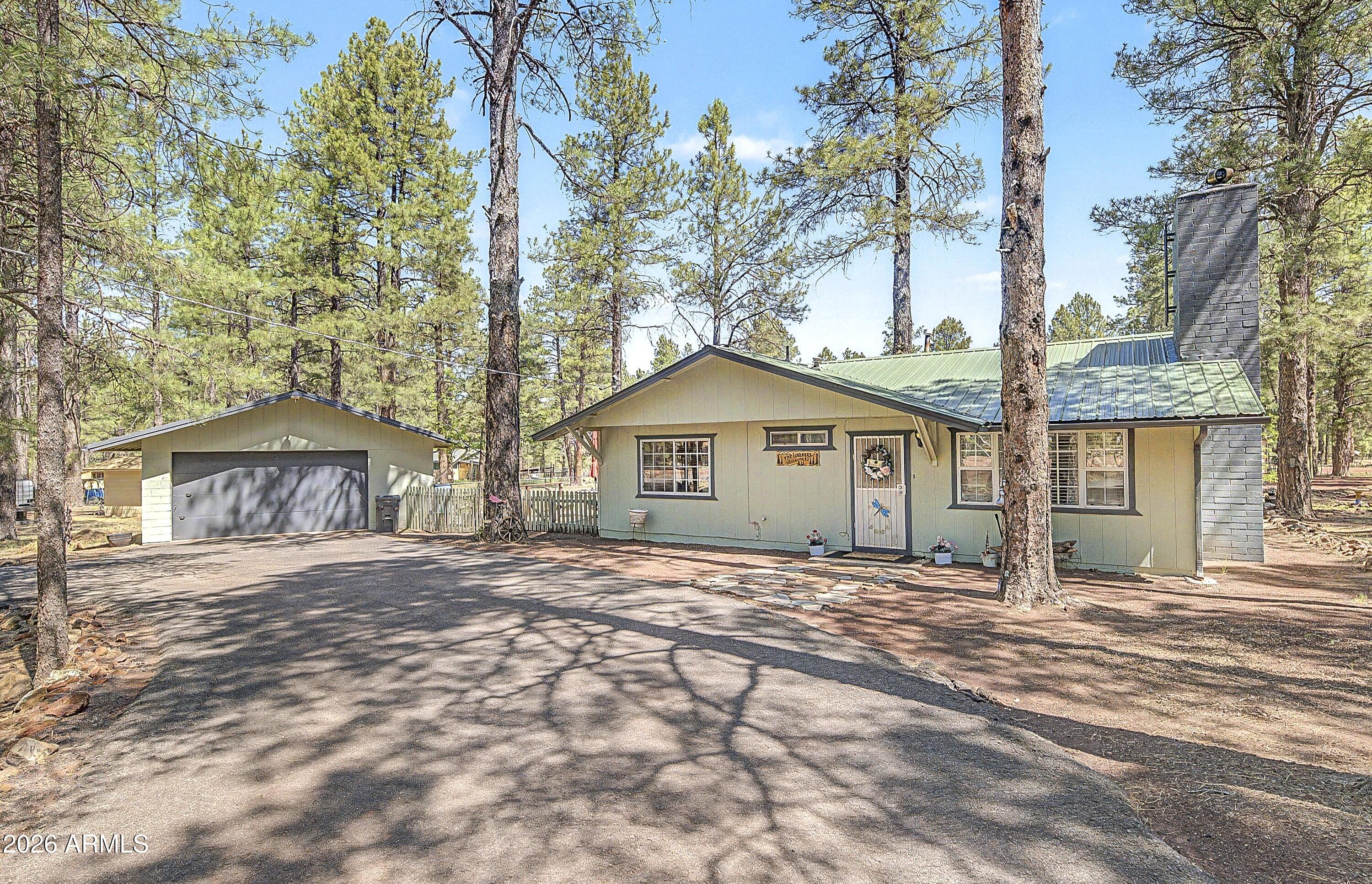 HORSE PROPERTY POTENTIAL! If living in cool pines near Kaibab National Forest is your dream, this property is for you. This 1383-sq ft, 3-bd, 2-bath home on 1.09-acres that features a 31x40 hay barn with three stables, horse stables, horse corral, 14x16 mechanical storage wash building, 24x26 ft oversized two-car garage with 16x8 ft door, a 40x14x18n ft Shelter Logic RV shelter with power and a 8x20 ft shipping container. The home has a large 10x24 ft kitchen and a fantastic wood stove plus forced air heating. The home has an Aquasana water filtration UV water treatment system to ensure clean water. There are two wood decks measuring 16x43 ft and 15 1/2x16 ft. This home is close to Williams with slopes, restaurants, bars and recreational opportunities. Hiking and riding trails close.