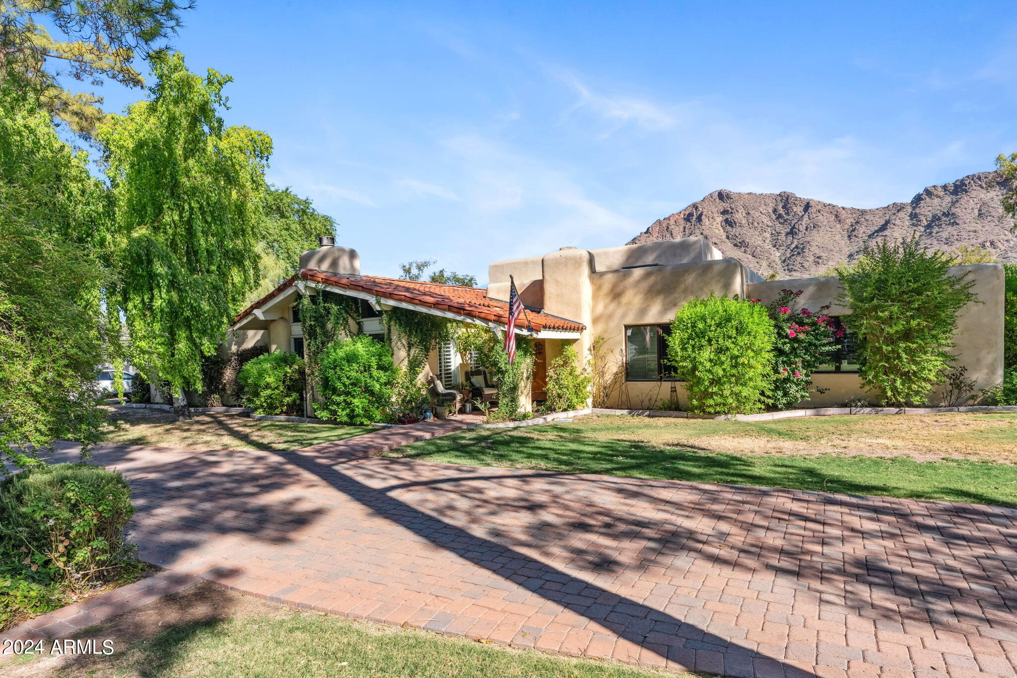 Welcome to the most desired and recognizable address in Arcadia: Exeter Blvd.   Rare opportunity to purchase this iconic address last offered in 1999!  This Spanish styled ranch home sits on a 35,072 sq ft  corner lot and is nestled in mature landscaping and with views of Camelback Mountain.  This 5 bedroom, 4.5 bathroom 6,100 sq ft  home was remodeled in 2006, adding a primary suite, office and game room.   Behind a hallway door is a wooden staircase that leads to a spacious loft (350 sq ft)  lined with windows and a small balcony overlooking Camelback Mountain, the backyard pool and spa, and spacious backyard.  In 2015 a large covered patio was added complete with gas fireplace, lighting and TV.   Move in as is or start over with your own vision.  This home offers many possibilities.