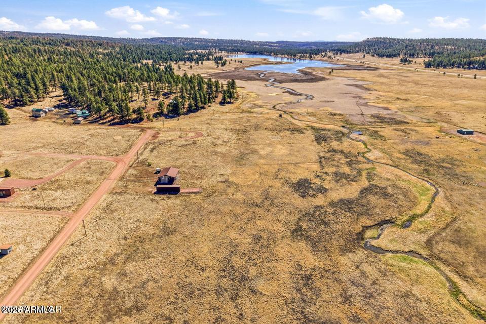 Rare opportunity in Luna Lake Village--1.66-acre parcel overlooking Luna Lake with year-round maintained access. One of the few properties in Alpine allowing RV use year-round, with manufactured homes also permitted. Level to gently sloping terrain offers easy access and multiple build sites. Power and water available. Bring your horses and enjoy the open space and fresh mountain air. Surrounded by the natural beauty Alpine is known for--world-class hunting, fishing, hiking and biking trails, plus nearby lakes, rivers, and streams--this property is perfect for the outdoor enthusiast. Escape the valley heat and claim your own slice of mountain paradise.
