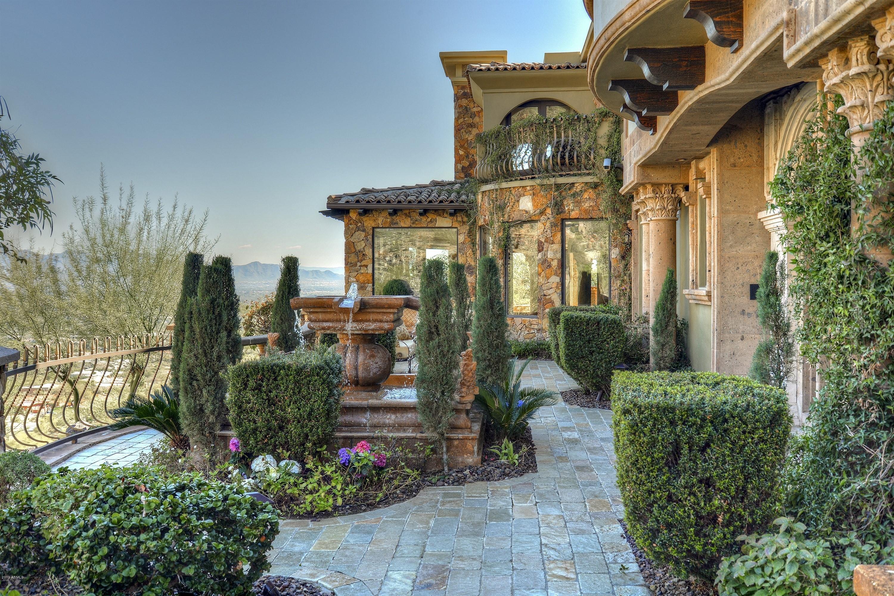 Gorgeous views, exquisite ornate details, masterfully designed, and expertly crafted, this grand guard-gated estate exudes elegance.  Thoughtfully positioned on a large, private, and quiet hillside lot, the home blends beautifully with the mountain terrain, and offers breathtaking views from its elevated position on Mummy Mountain. The home showcases exceptional craftsmanship, materials, and design. Marble and wood floors, custom millwork, coffered ceilings, fine marble countertops, French doors, and 8 gorgeous fireplaces, flawlessly create an ambiance of beauty and quality. Whether hosting a black tie event, or enjoying a small intimate gathering, all will be touched by this truly extraordinary estate.