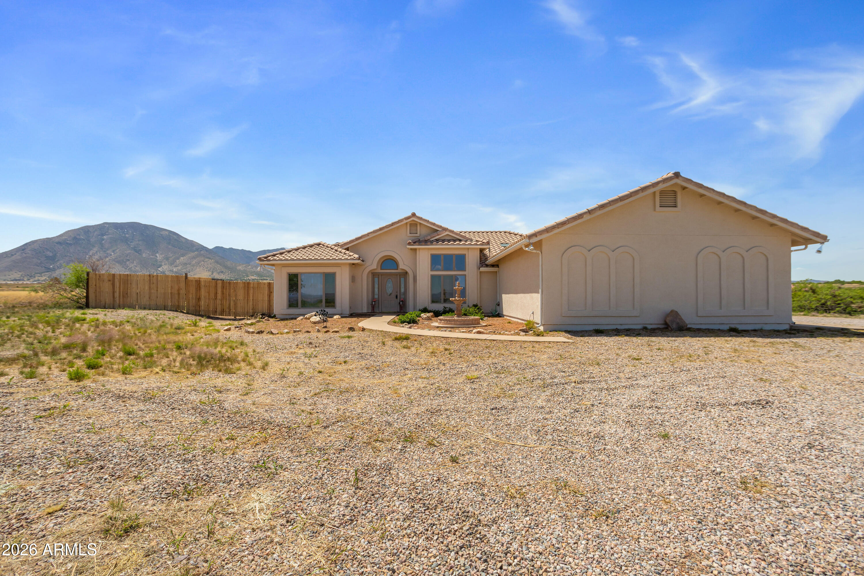 Custom Home Set on 7.40 acres with a PRIVATE WELL, paved road, stunning mountain views and ideal east/west exposure, this well-maintained home offers new exterior paint, newer appliances including the HVAC system, 3 bed, 2 bath plus a den or make it another bedroom home offers space, comfort, and privacy. Featuring 2,156 sq ft of living space, the split floor plan includes a spacious great room, cozy fireplace, and a dedicated study/den; perfect for working from home. The kitchen is equipped with a breakfast bar, island, pantry, and included appliances. The primary suite offers dual sinks and a functional layout. Landscaped front and rear yards feature a blend of natural desert, grass, and a low maintenance design on rolling hills! The backyard is set up for entertaining facing the Huachuca Mountains and a fenced area for your horses - approx an acre or expand it and make it your own!!  Plenty of room to add any out building too!