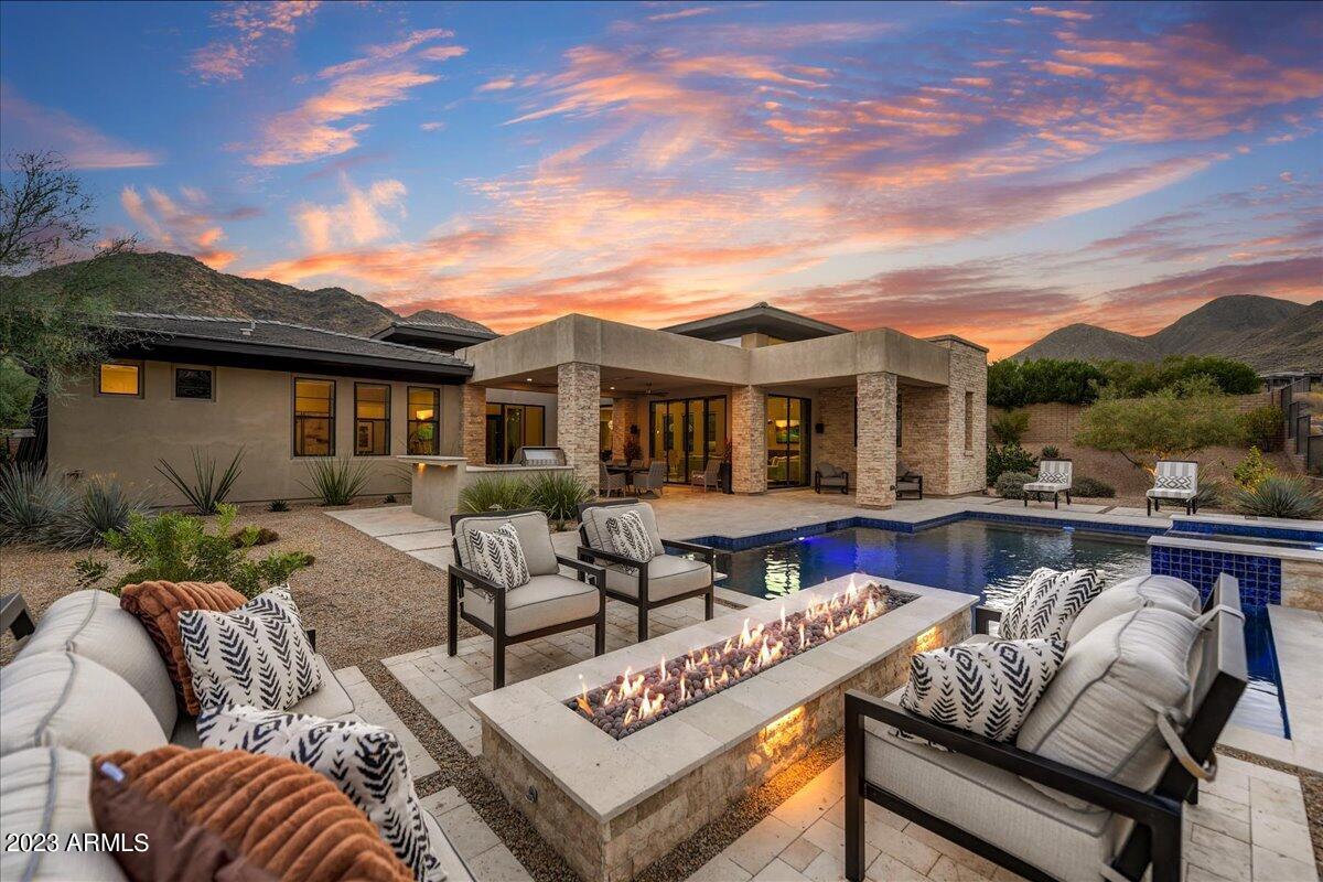 Enjoy the sheer beauty of this stunning home that abuts the preserve offering tranquility and privacy. As you walk into your courtyard you will be immediately impressed by this impeccably designed floorplan. With tons of upgrades including a gourmet kitchen with highlighted niches to show off your art, a large kitchen island, butlers/wine pantry, and upgraded Wolf appliances just to name a few. This popular Laurent floor plan boasts a huge family room with 15-foot ceilings and sliding doors overlooking the beauty of the mountains and outdoor living.  In addition to 3 en-suite bedrooms with fantastic views, you have two offices, one located off of the family room and the other off of the media/movie room. This second office could easily be converted to a 4th bedroom. Exterior features are Enjoy that evening swim or relax in your elevated spa while seeing the flicking flames of your linear gas fire pit. Two large covered patios with custom outdoor kitchen including a Lynx 36-inch grill will make entertaining a dream. There are a total of Three attached garages. In the attached two-car garage you have epoxy flooring and are wired for electric vehicle charging. The 3rd car garage has been converted into a gym with Dynoflex sport tiles and a mini-split system for full HVAC control this garage can easily be converted back. This gated home will not disappoint and is pure perfection. Come see for yourself.