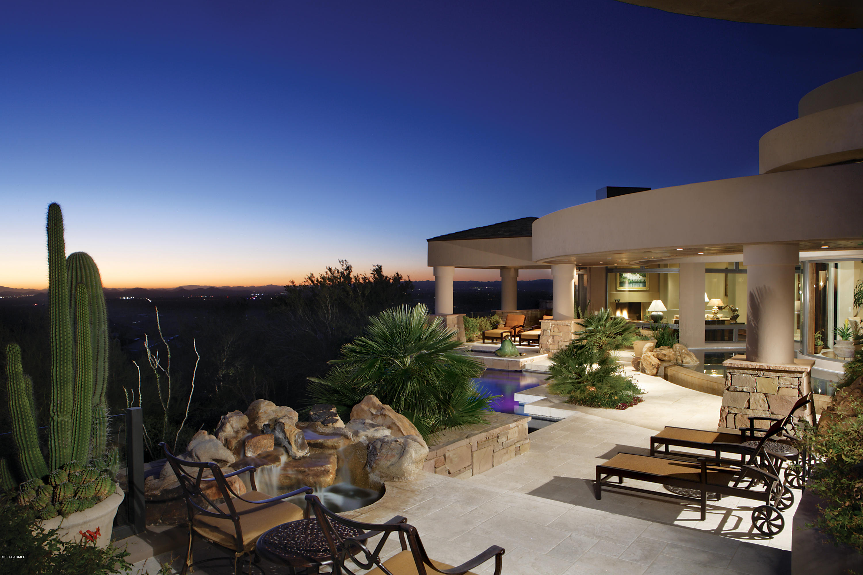 This stunning soft contemporary masterpiece is nestled on a majestic hillside lot within the exclusive gated community of Estancia. Custom designed by architect Hugh Huddleson and built by Glenn Farner Construction, this amazing property offers privacy, solitude and unparalleled Pinnacle Peak, sunset and city light views- a true ''Zenlike'' experience! The outdoor views are rivaled only by the highest grade of interior finishes, with custom travertine and wood floors, curved moldings, private master retreat with separate gym or yoga room, billiard room and three additional guest suites. Open kitchen flows easily to cozy family room with fireplace, while dramatic living room, wet bar and dining room allow for the best in entertaining.  Separate study/office and, naturally, an amazing wine cellar complete this very special home.  Enjoy year round, seamless indoor to outdoor living with telescoping patio doors leading to an outdoor oasis, with reflecting pool, negative edge pool, hot tub and sitting area complete with overhead built-in heat lamps and fireplace.