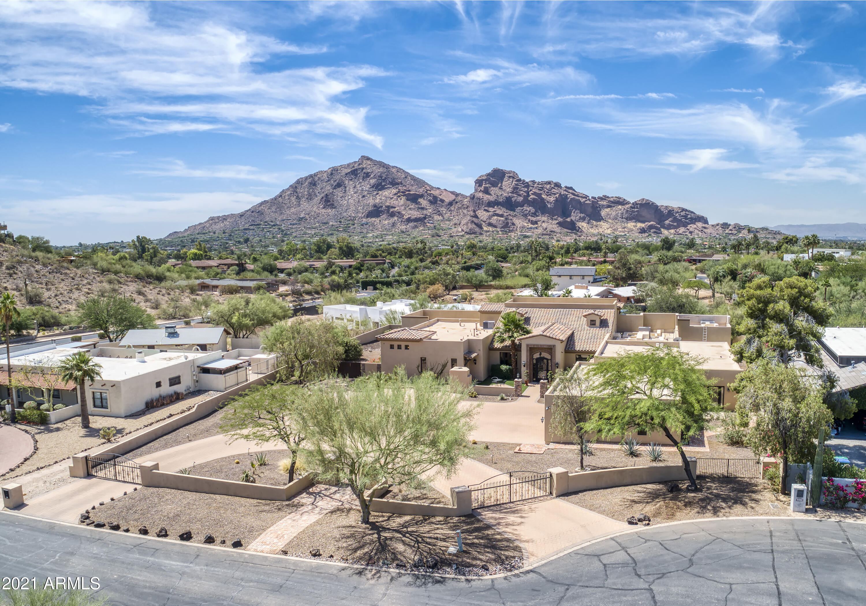 This Privately gated PV  property was completely rebuilt in 2012 using high quality finishes. Nestled between Mummy Mountain and the Phoenix Preserve allows for full unobstructed Camelback Mountain views. This 7,222 sq. ft. home with it's oversized 5 bedrooms, 5.5 baths. Grand entry, great room with custom stone work, fireplace and soaring vaulted ceilings is an entertainers dream. Master suite has a private office space, fireplace, his and her w/c, large jetted tub and oversized walk in close. Custom kitchen with 2 42'' refrigerators, 2 dishwashers, Viking gas range 3 ovens, wine frig. Open to family room breakfast  room and butler's pantry. Separate office, fully equipped bar and upper mezzanine and covered outdoor balcony. Separate Casita, pool, 4 car oversized garage and more