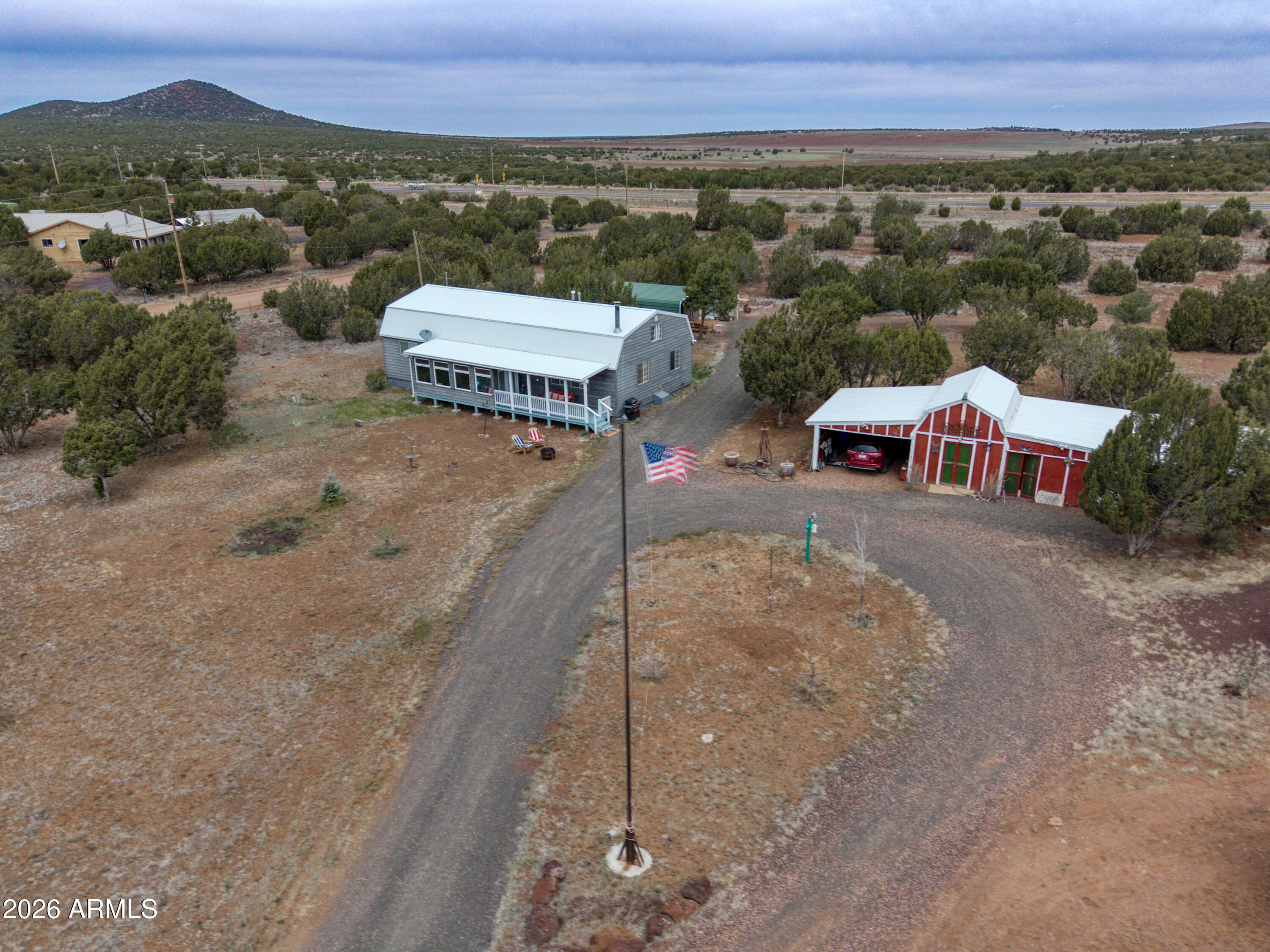 Located in the cool white Mountains of Arizona, just outside of Show Low, is this wide open, flat 5.5-acre Ranch-Estate with panoramic views! Ideal horse property with its own private well, featuring a 1,568-square-foot traditional ranch-style home, durable metal roof, and a 3-bed, 2-bath home. The property encompasses a huge, oversized 3/4 enclosed carport with an attached back storage area accessible through a roll-up door, ideal for use as a 2-car garage. Huge, oversized roundabout driveway allowing for RVs, flatbed trailers, and plenty of parking. Also on the property is a barnlike structure with an attached covered area for vehicle(s) or ranch equipment on the west side and a covered storage area on the east side. As you enter the fully remodeled home through the enclosed Arizona room you'll have access to all parts of the home. The first thing you will notice to the right is an updated open kitchen with Granite Countertops, a Ceramic kitchen floor, and a separate full wet bar with access to the pantry and laundry room. To the left are 2 of the 3 bedrooms. Going to the right through the kitchen is the great room, featuring an eating area and a pellet stove, surrounded by a sculpted brick wall, sitting on a raised brick platform that leads to the living area.