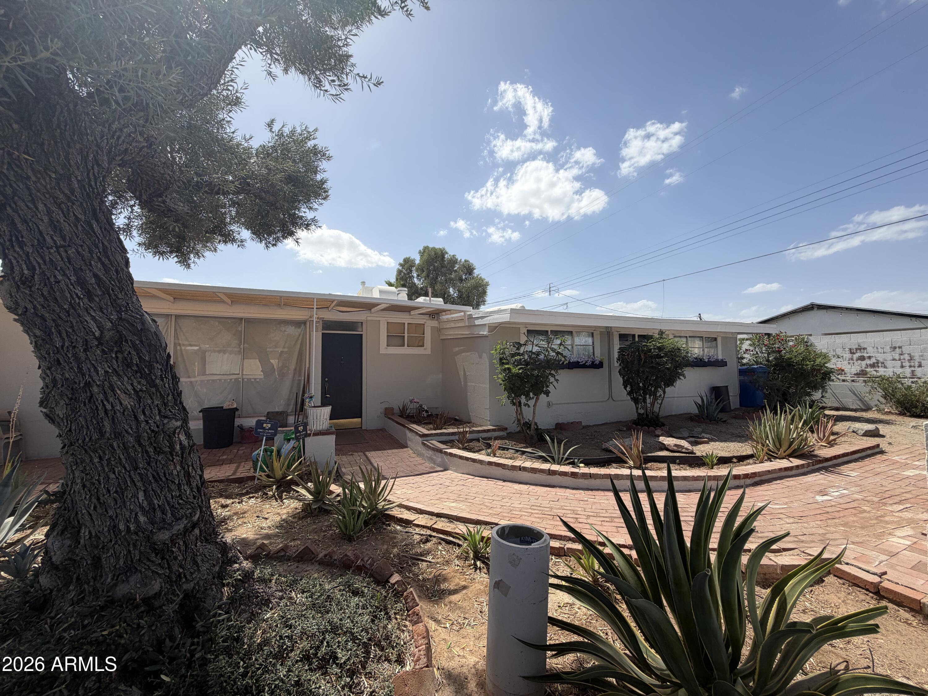 Unique opportunity to own in one of the Valley's fastest-growing neighborhoods at an almost land-value price -- a rare find in this area and priced to sell quickly! Built by an architect in 1951, this home is filled with character, warmth, and timeless charm. Brick floors throughout create a very rare design, painted block interior walls, sloped ceiling with exposed conduit for lighting and fans! Ideally located with unbeatable access to Highway 51 and Interstate 17, you can reach almost anywhere in the Valley within minutes. The property features a beautiful PebbleTec pool, spacious living areas, and a detached livable space perfect for multigenerational living, guest quarters, or added flexibility. Homes and land in this area are moving fast, and opportunities like this won't last long!