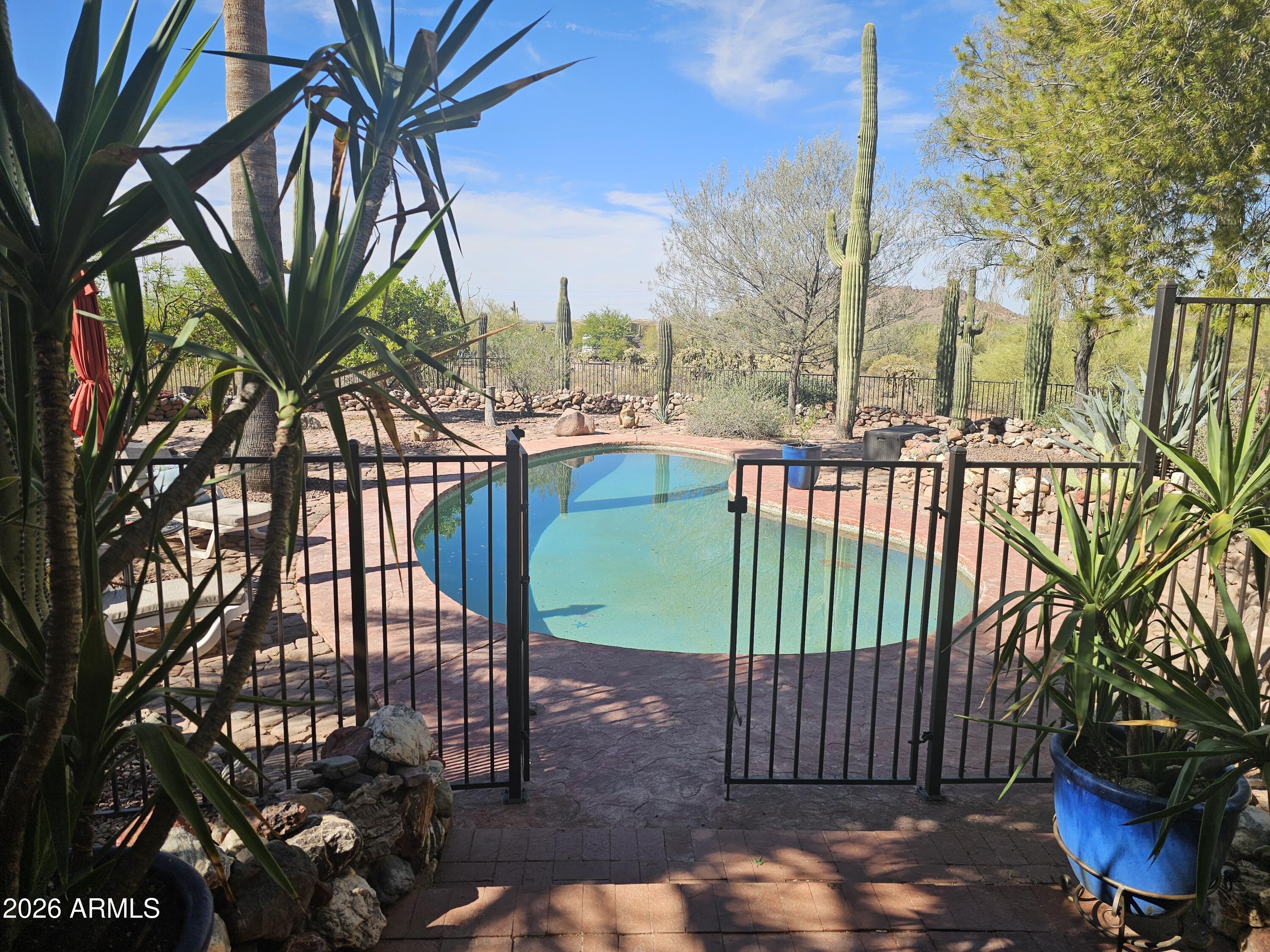 OVER 1.5 ACRES • NO HOA • PRIVATE POOL • 960 SQ FT WORKSHOP
Rare opportunity to own one of Gold Canyon's most versatile lifestyle properties. Situated on over 1.5 acres, this 3-bedroom home plus bonus room offers privacy, flexibility, and subtle Frank Lloyd Wright-inspired design. Relax or entertain in your private backyard oasis featuring a sparkling pool, outdoor kitchen, mature landscaping, and winding stone pathways. The expansive corner lot provides room for horses, RVs, or a future casita. The 960 sq ft detached garage/workshop with office and additional rooms is ideal for collectors, hobbyists, home-based businesses, or extra storage. If you've been searching for acreage, no HOA, and the freedom to make a property your own, opportunities like this are rare.